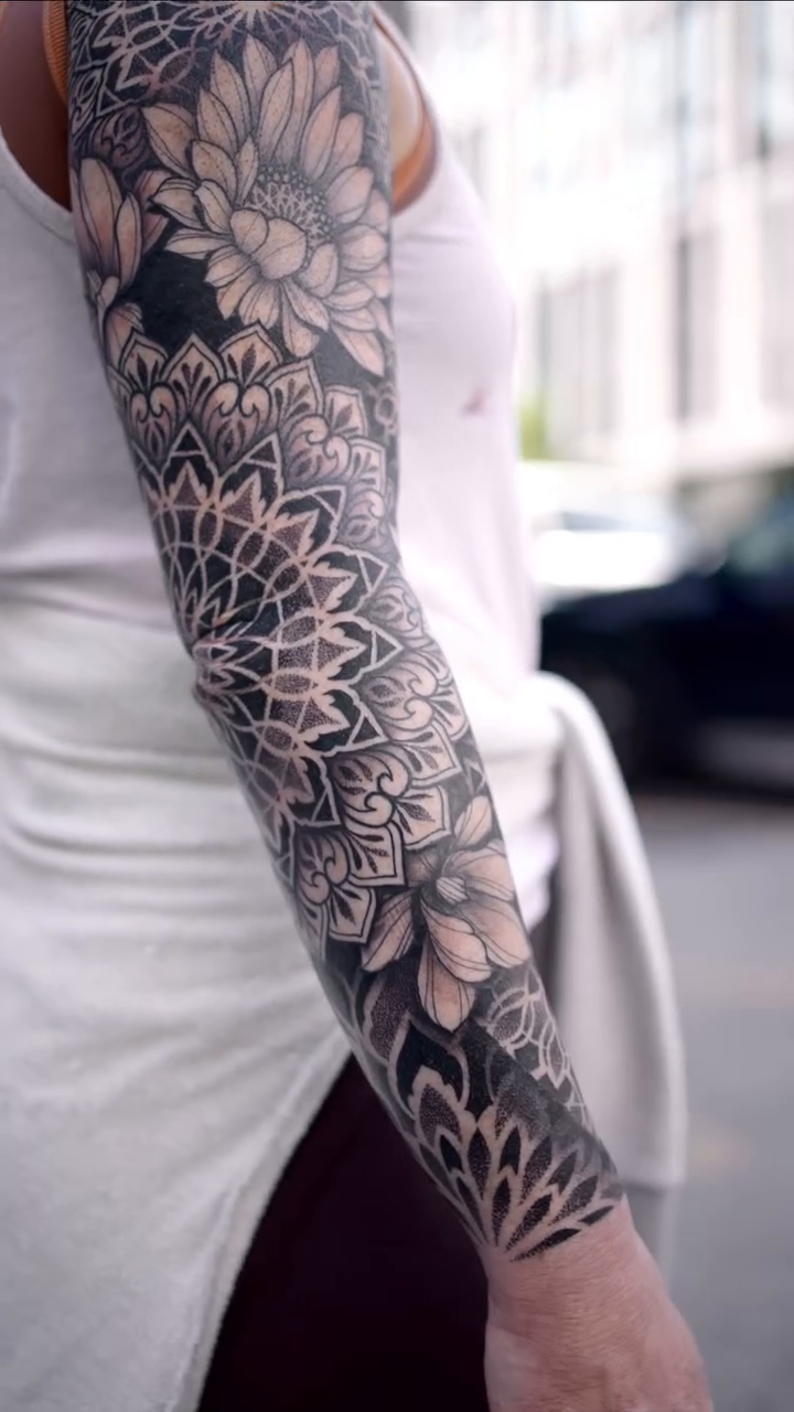 Full sleeve mandala and floral geometric tattoo by Laure Conzales