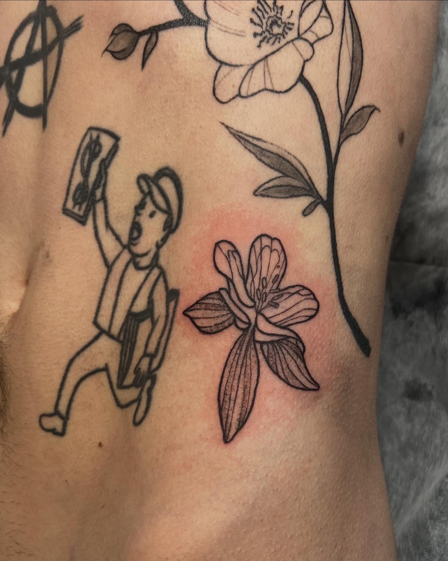 Cartoon figure with flowers black and grey tattoo on the ribs by sarah bug