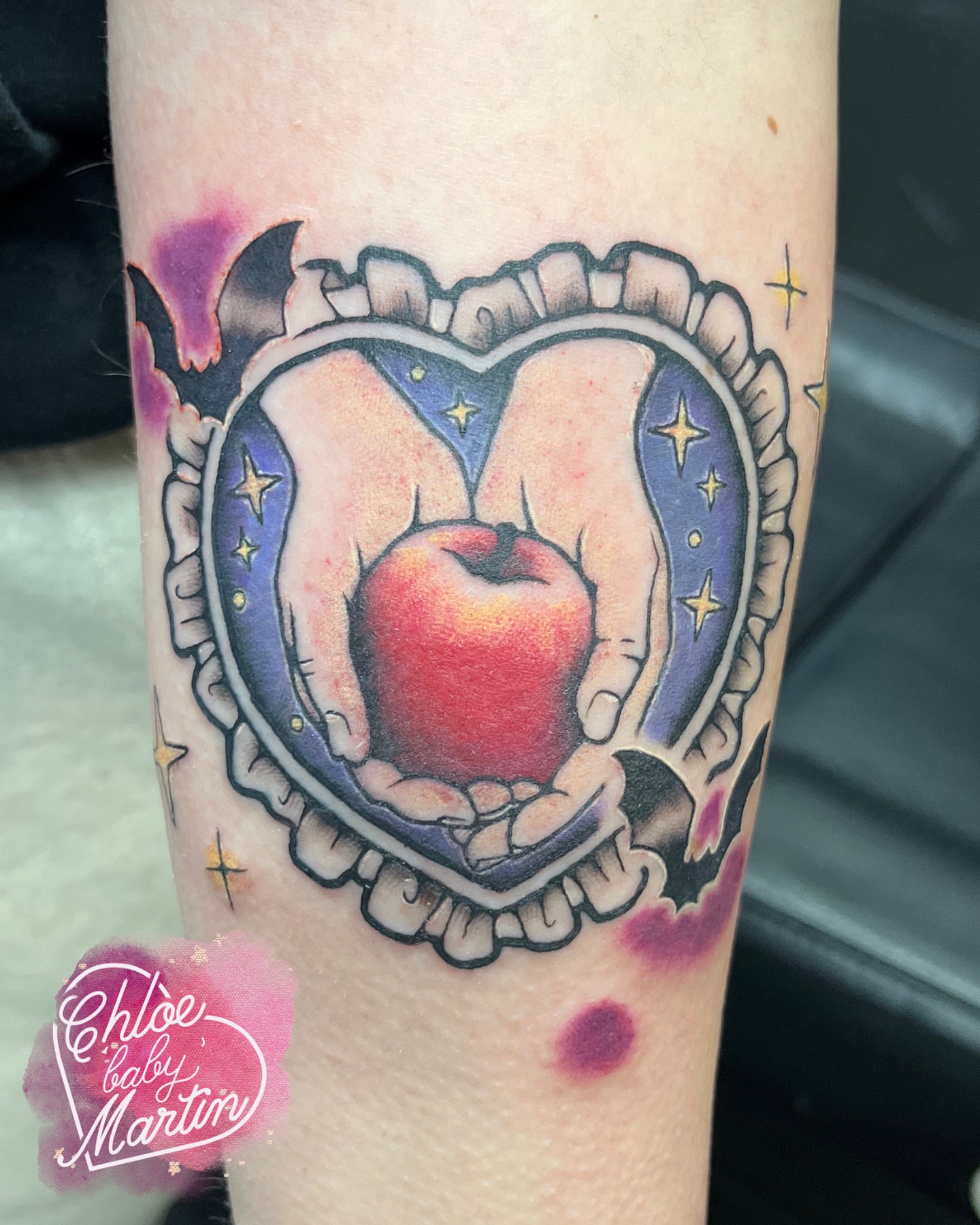 Apple in hands American traditional tattoo on the forearm by Chloe ‘baby’ Martin