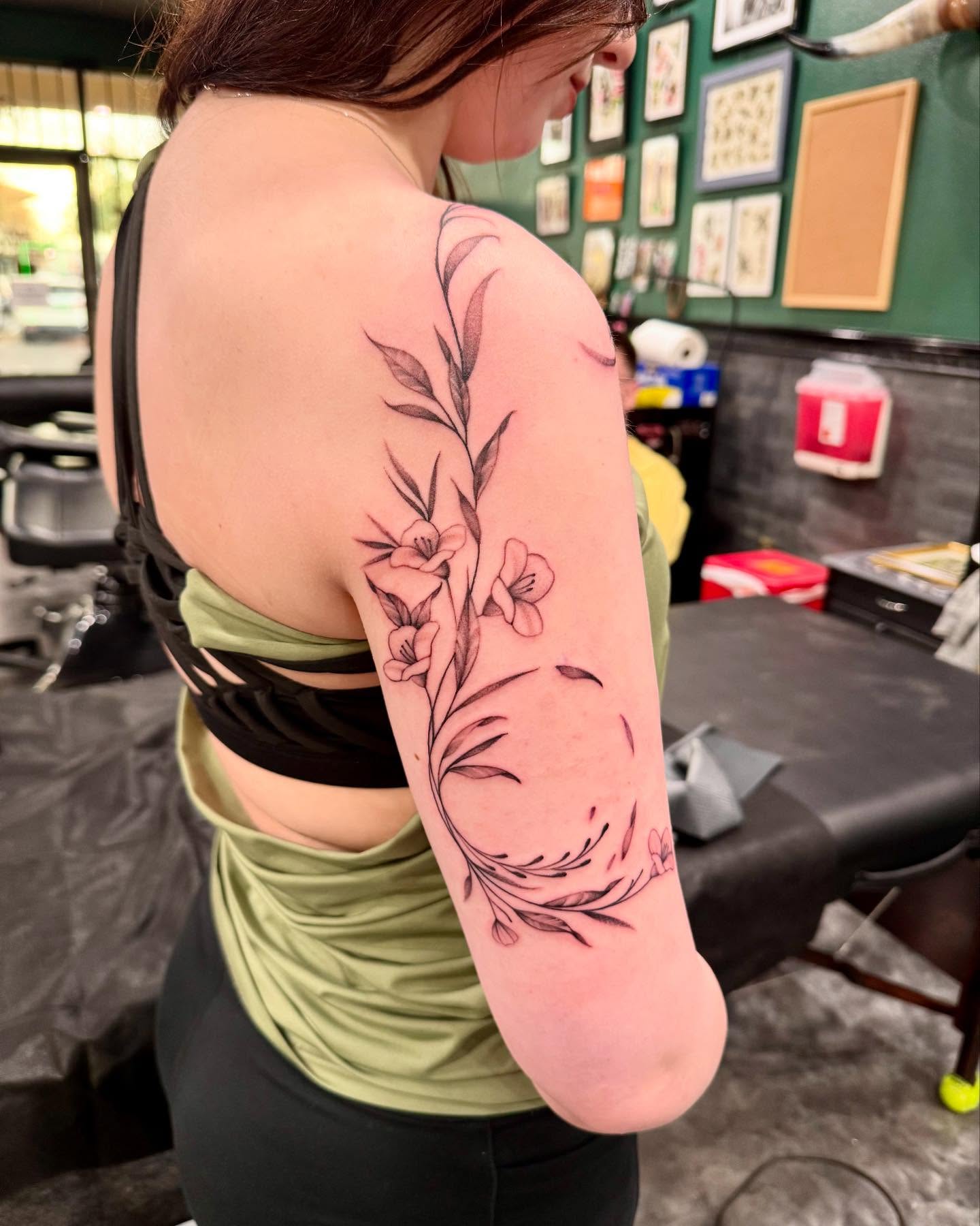 Floral arrangement black and grey tattoo on the upper arm by Jay Espinoza-AZ Tattooer