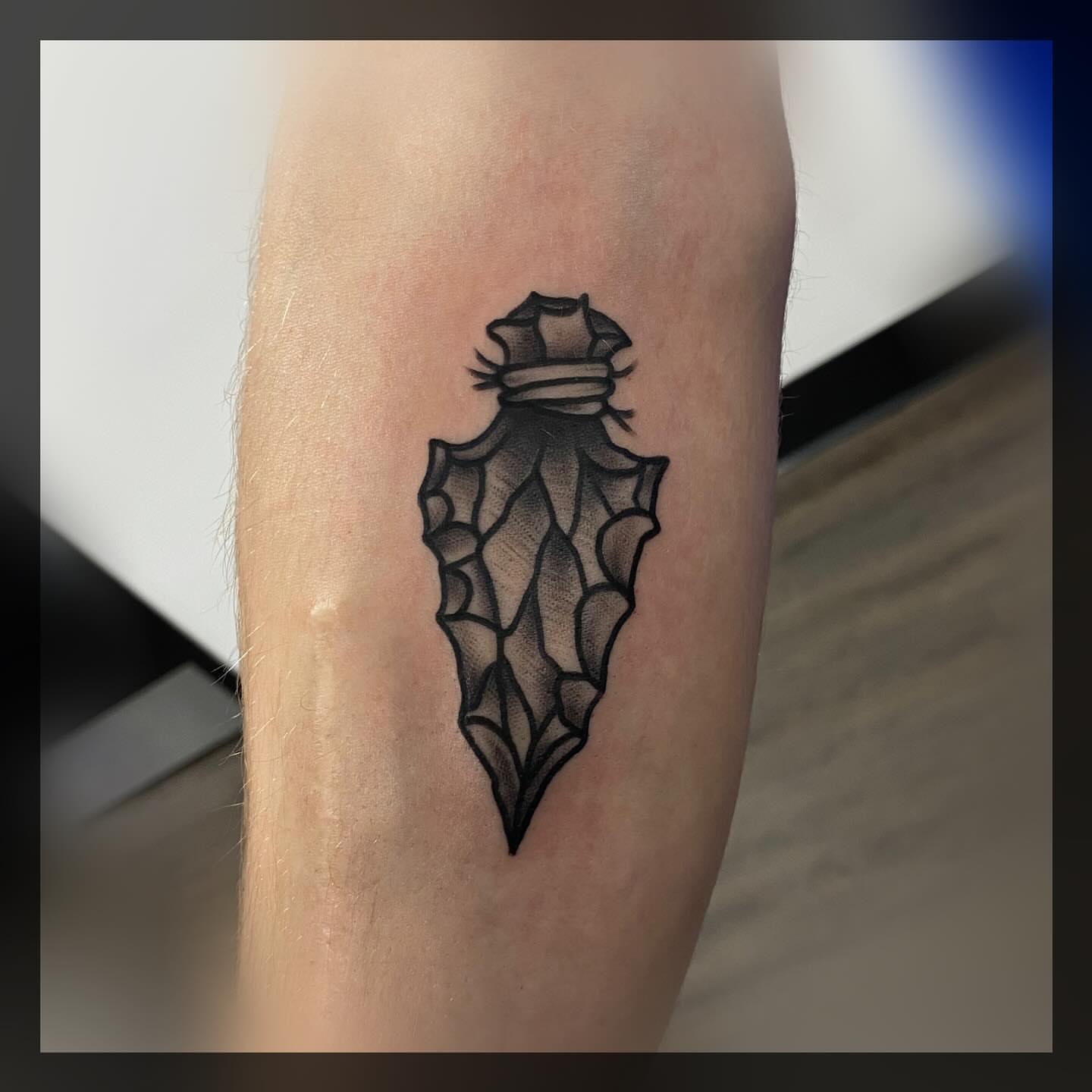 Arrowhead dotwork tattoo on the forearm by Romans
