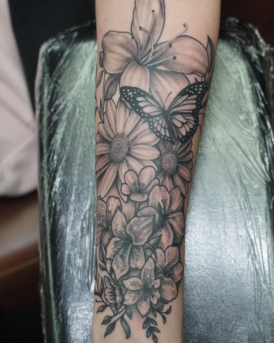 Flowers and butterfly realism tattoo on the forearm by James Reed Tattoo artist