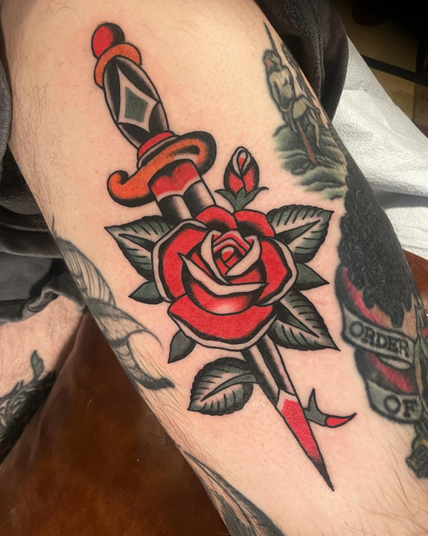 Rose and dagger American traditional tattoo on the forearm by Mike Hudgins
