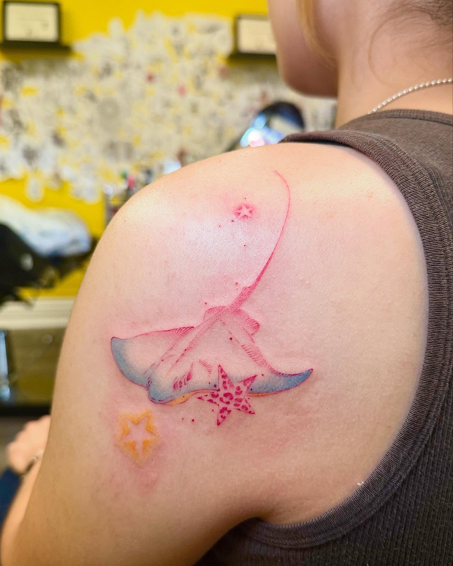 Ray and starfish watercolor tattoo on the shoulder by Echo