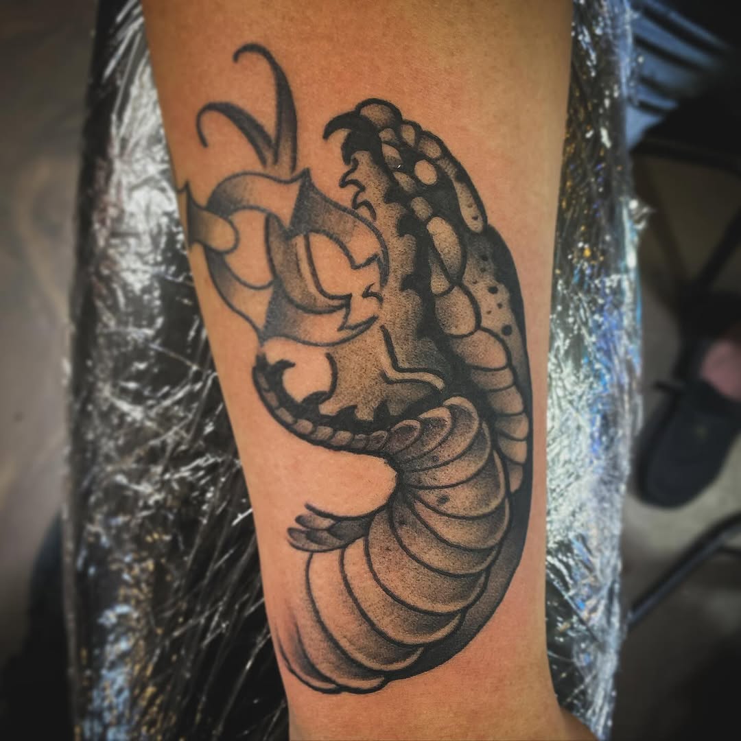 Snake head realism tattoo on the forearm by Cody Wolfe