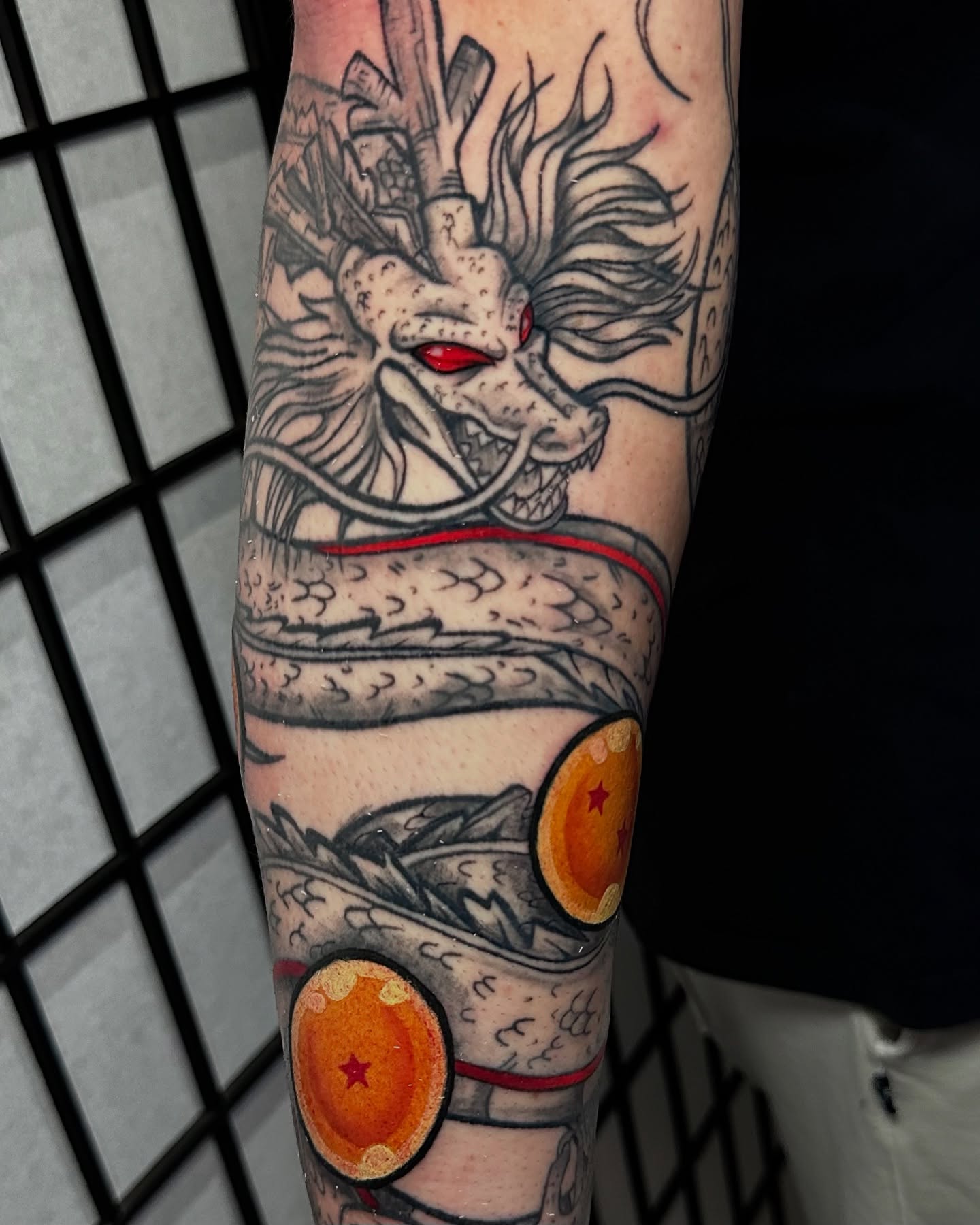 Dragon and dragon balls American traditional tattoo on the forearm by Taylin Johnson- Illustrative Blackwork, Columbus, Ohio