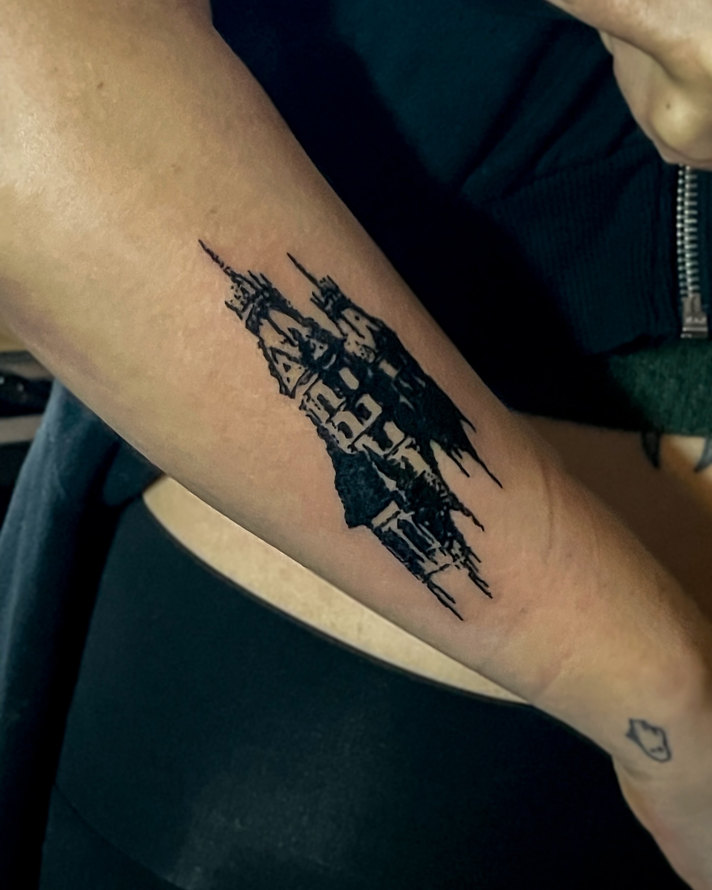 Castle silhouette black and grey tattoo on the forearm by Amy