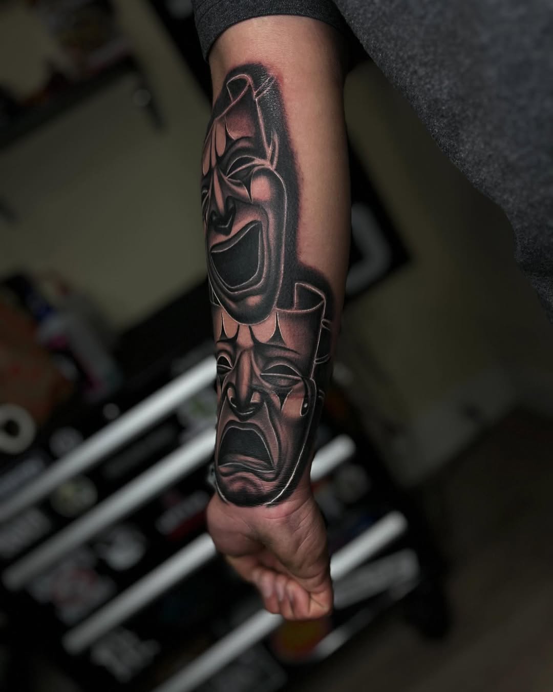 Comedy and tragedy masks realism tattoo on the forearm by Tattoo Artist