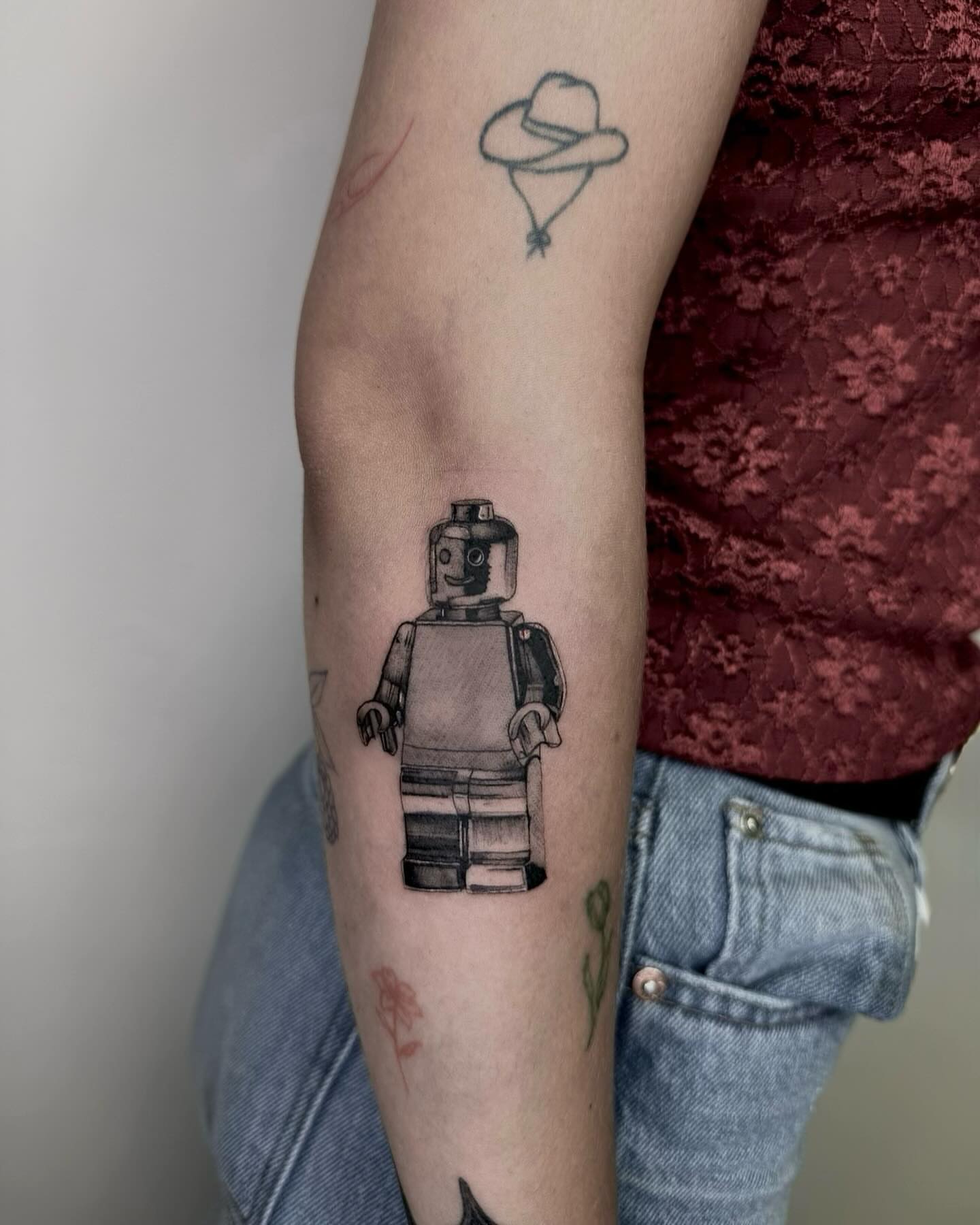 LEGO minifigure black and grey tattoo on the forearm by Rachel