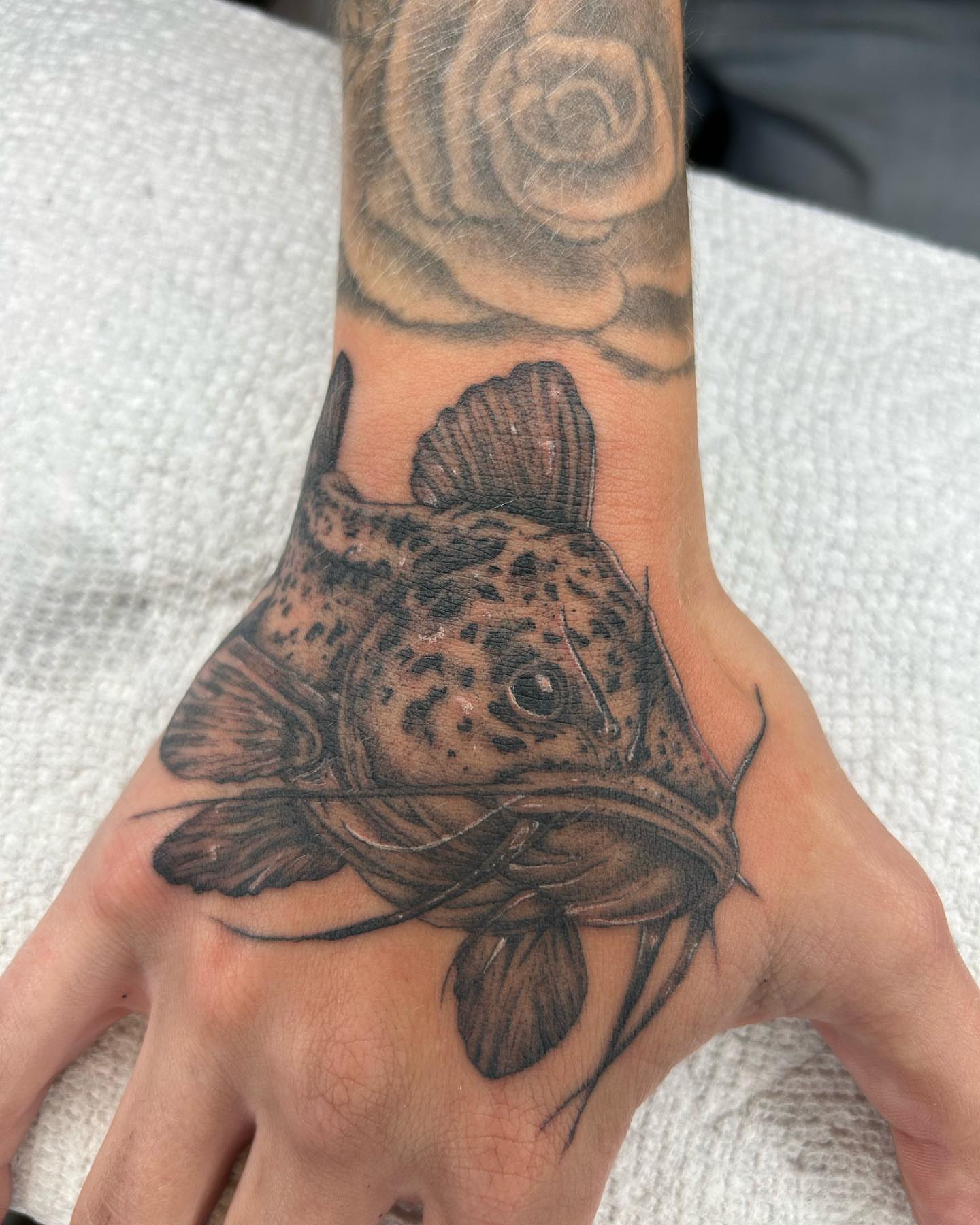 Catfish realism tattoo on the hand by Alex Lang