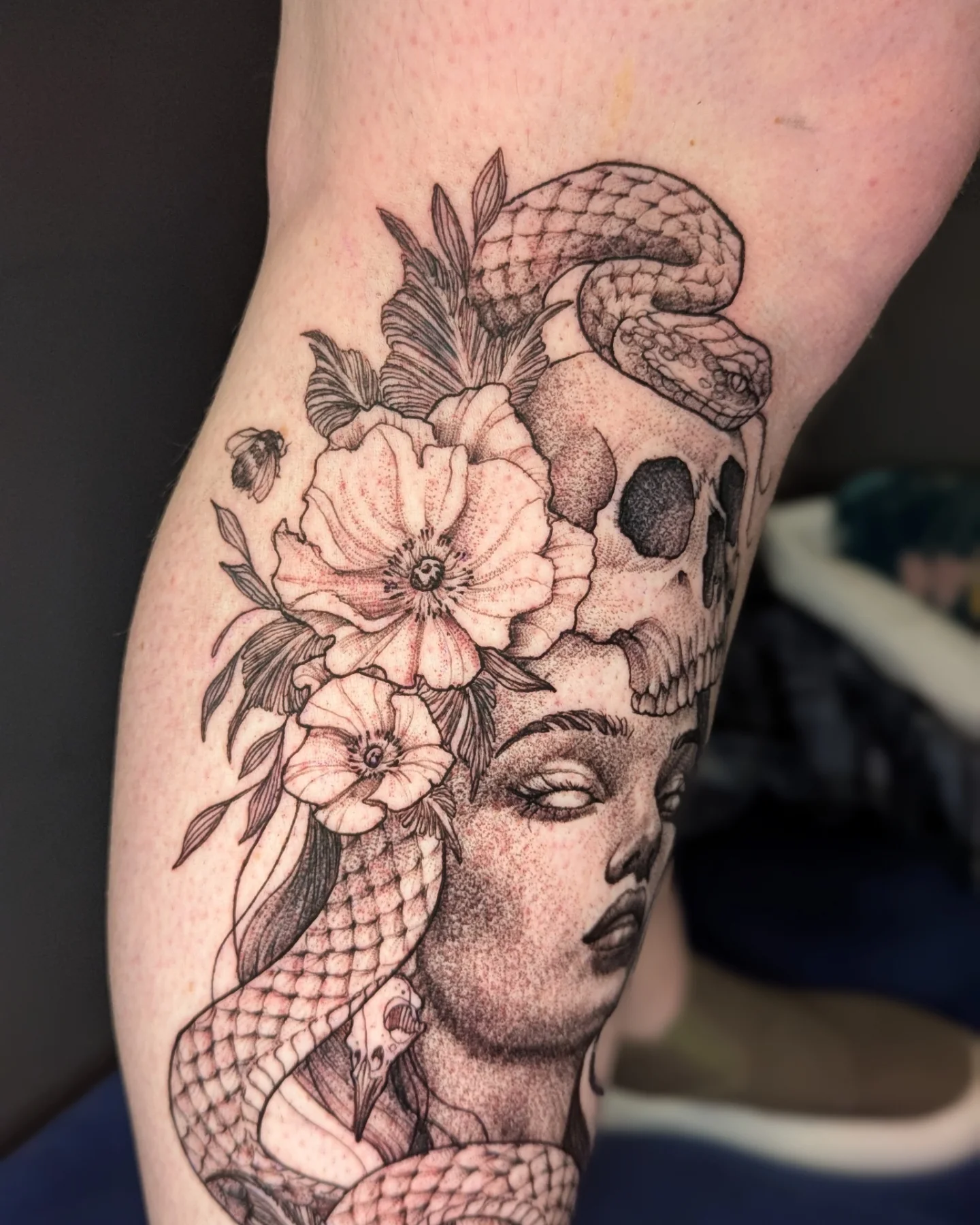 Woman with snake and flowers dotwork tattoo on the forearm by Bethany Jane Tattoos