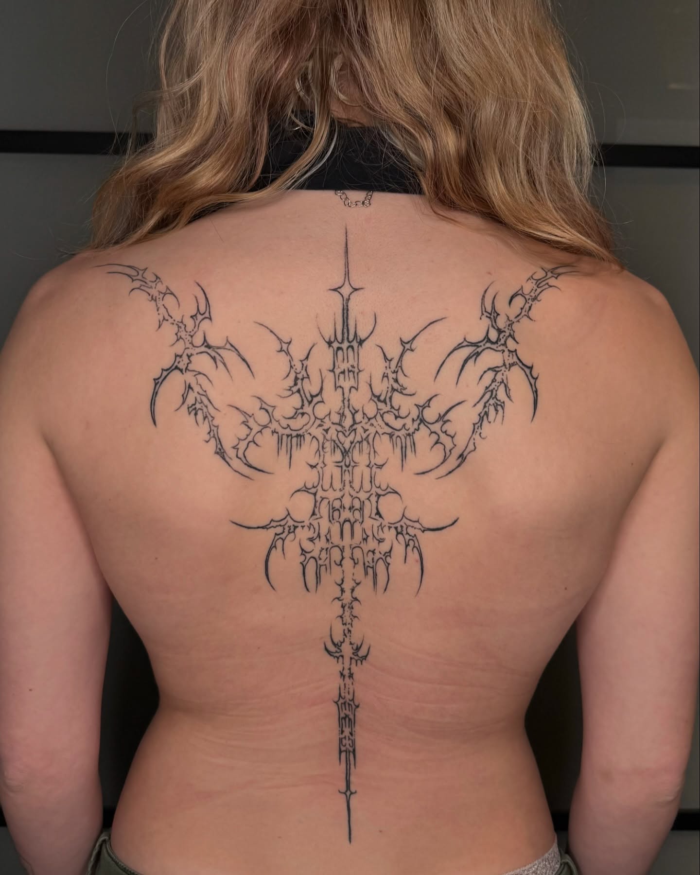 Cross black and grey tattoo on the back by Milo