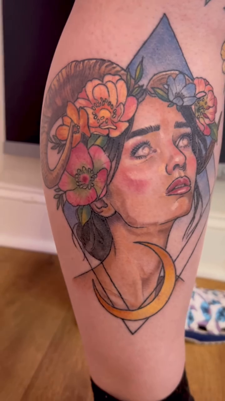 Woman with ram horns and flowers neo-traditional tattoo on the leg by Jes Petrie Tattoos