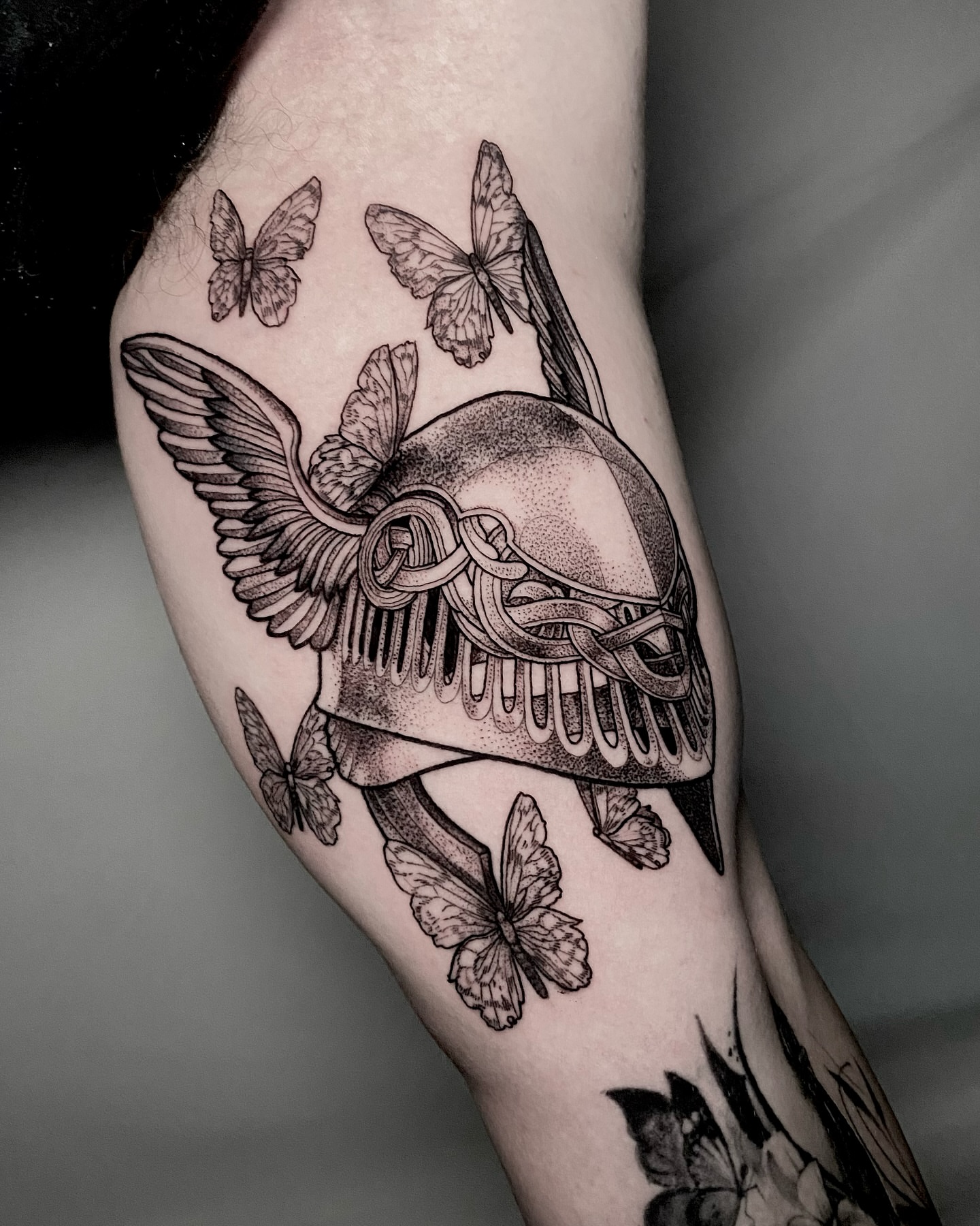 Winged skull with butterflies dotwork tattoo on the forearm by Rowan Starr
