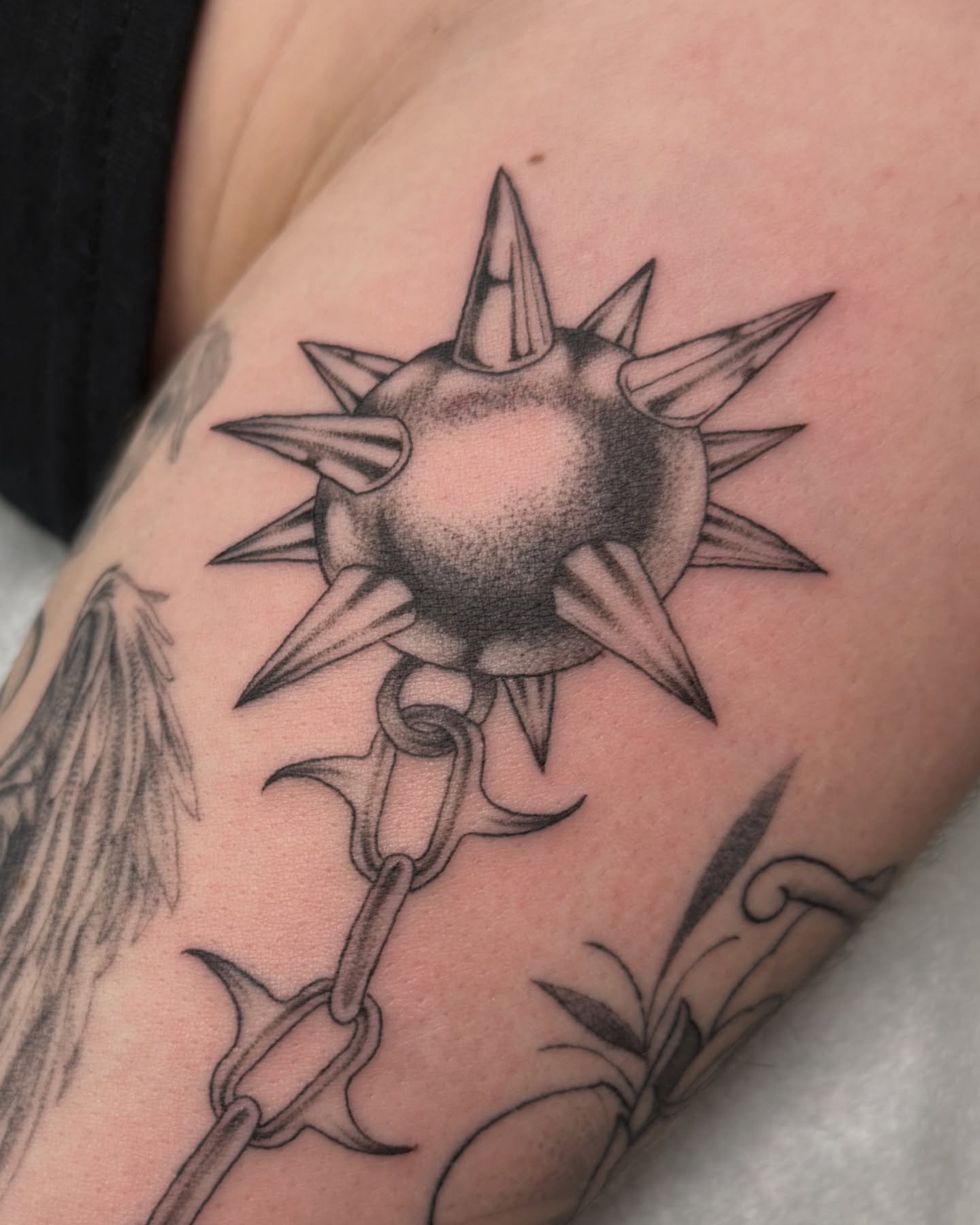 Spiked ball and chain black and grey tattoo on the forearm by liliana lopez