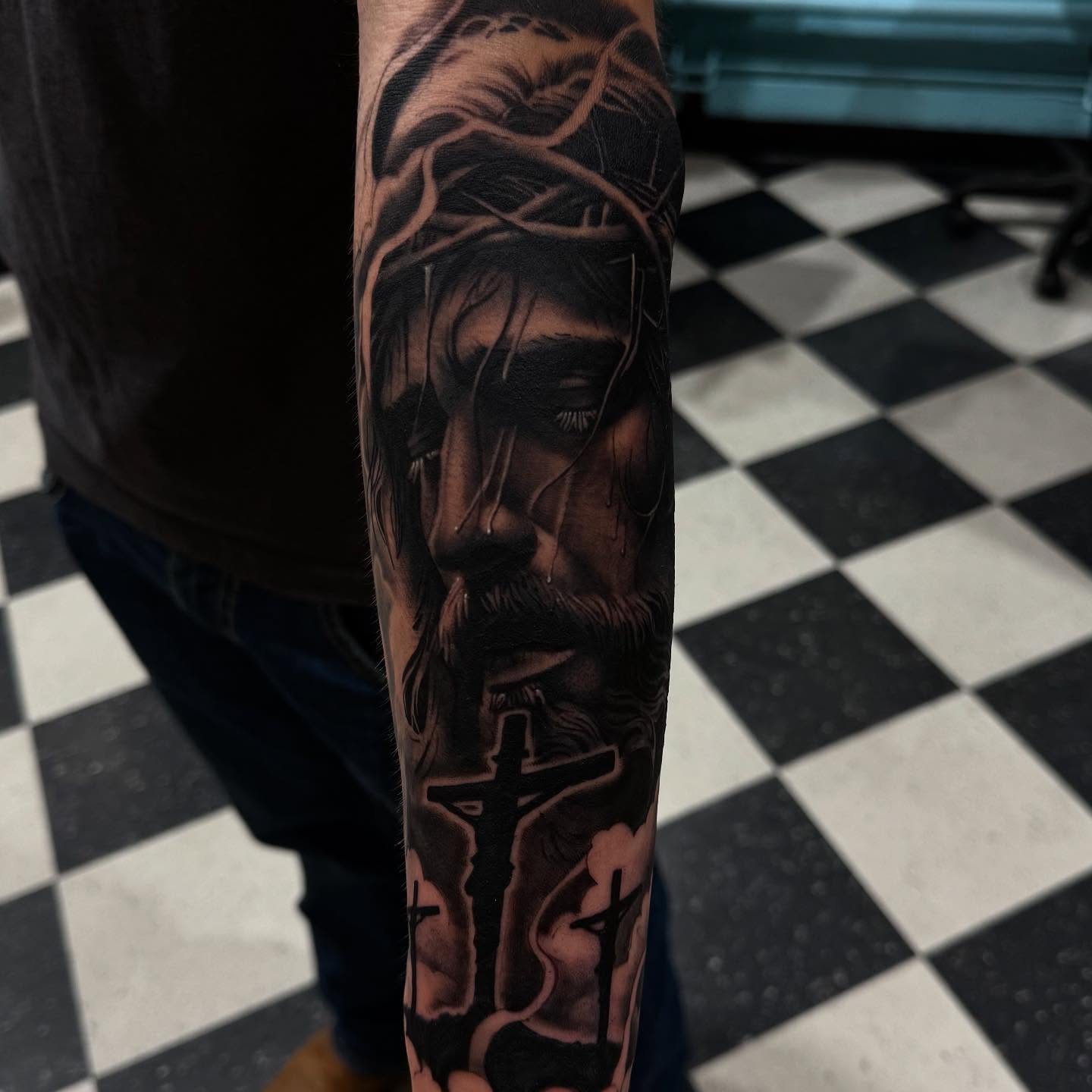 Jesus Christ realism tattoo on the forearm by Wolf of Wall St.