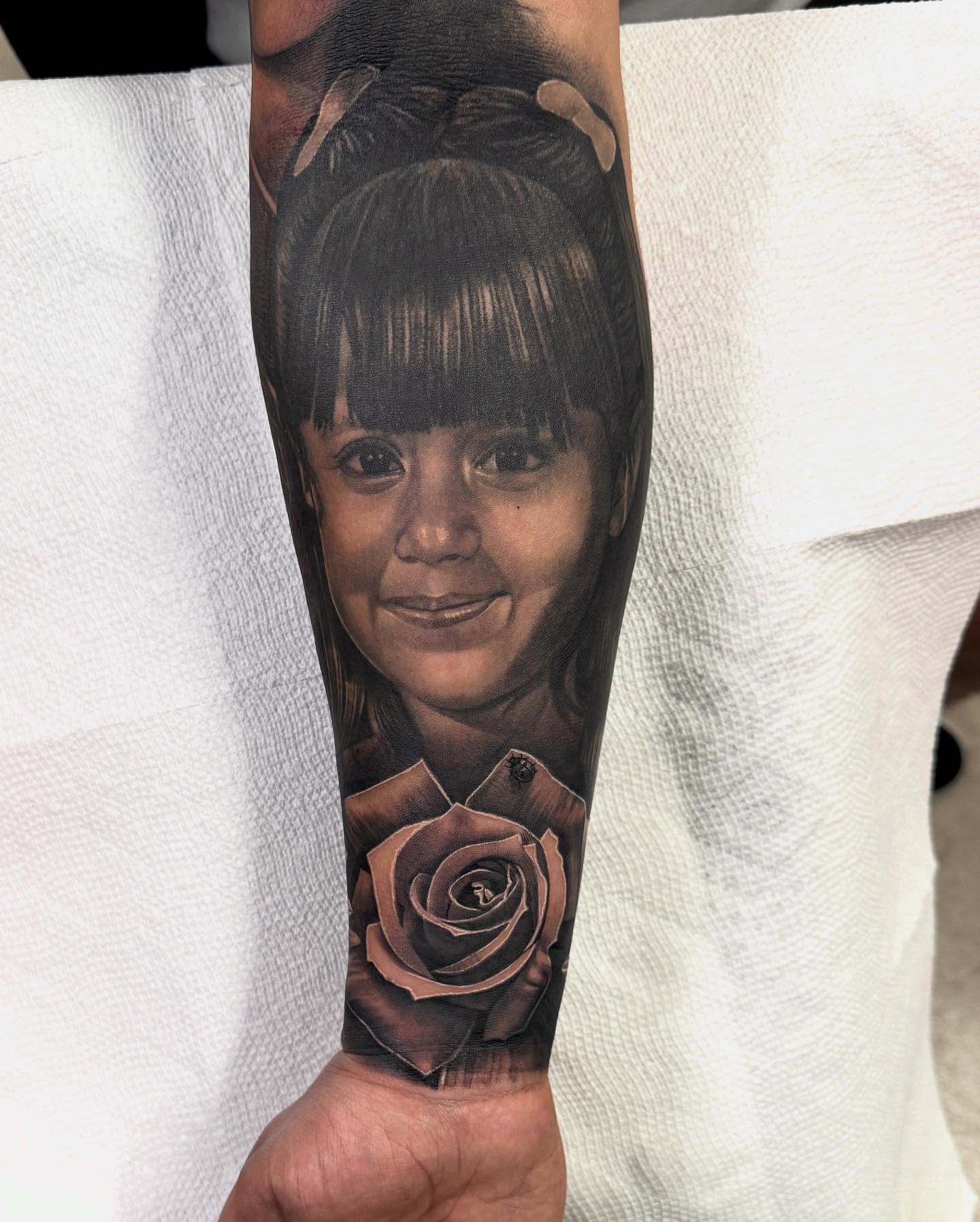 Child and rose realism tattoo on the forearm by Anthony Duran
