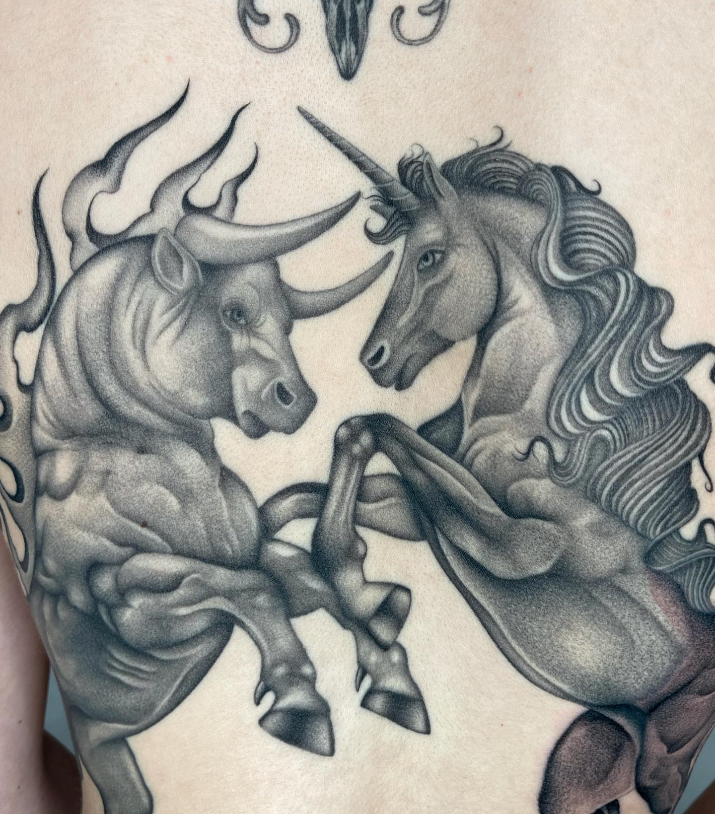 Bull and unicorn realism tattoo on the torso by Tiyanna Garlic