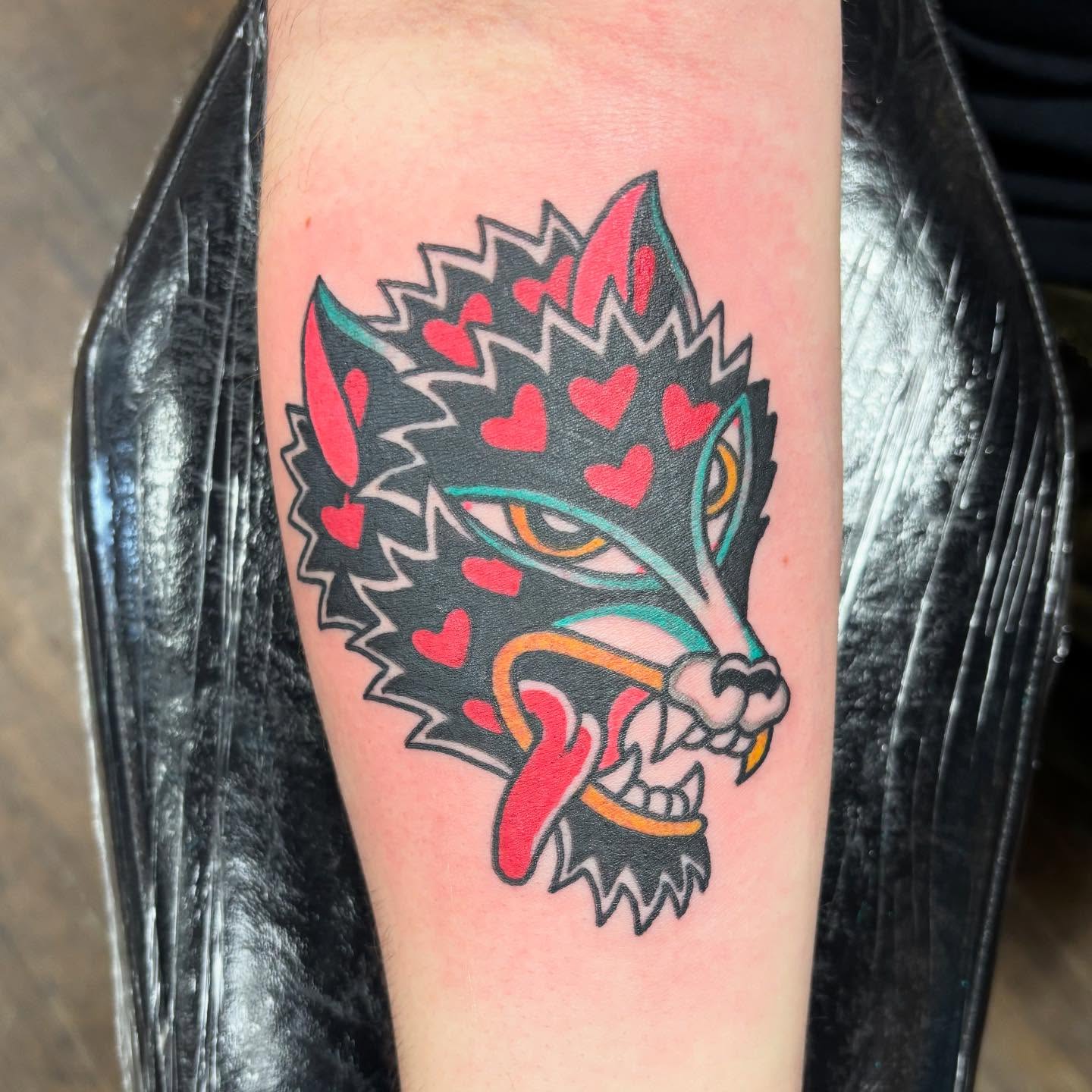 Wolf with hearts American traditional tattoo on the forearm by Dave
