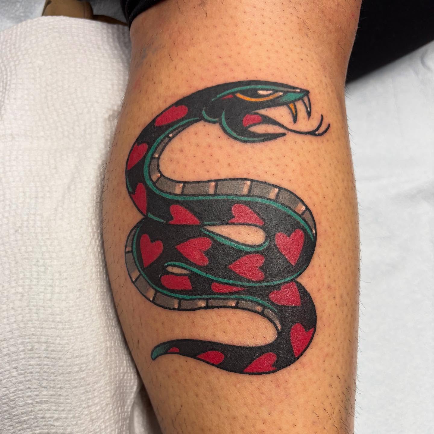 Snake with hearts American traditional tattoo on the forearm by Dave