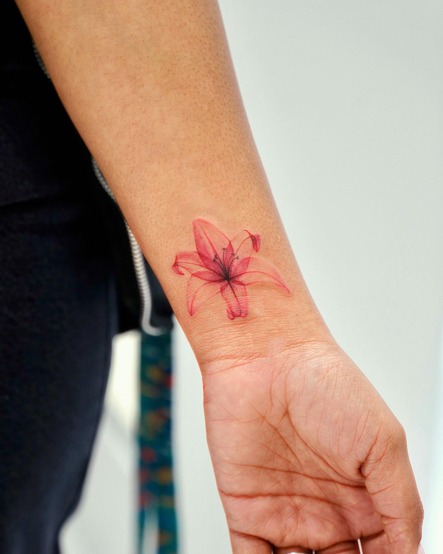 Lily watercolor tattoo on the forearm by David H.