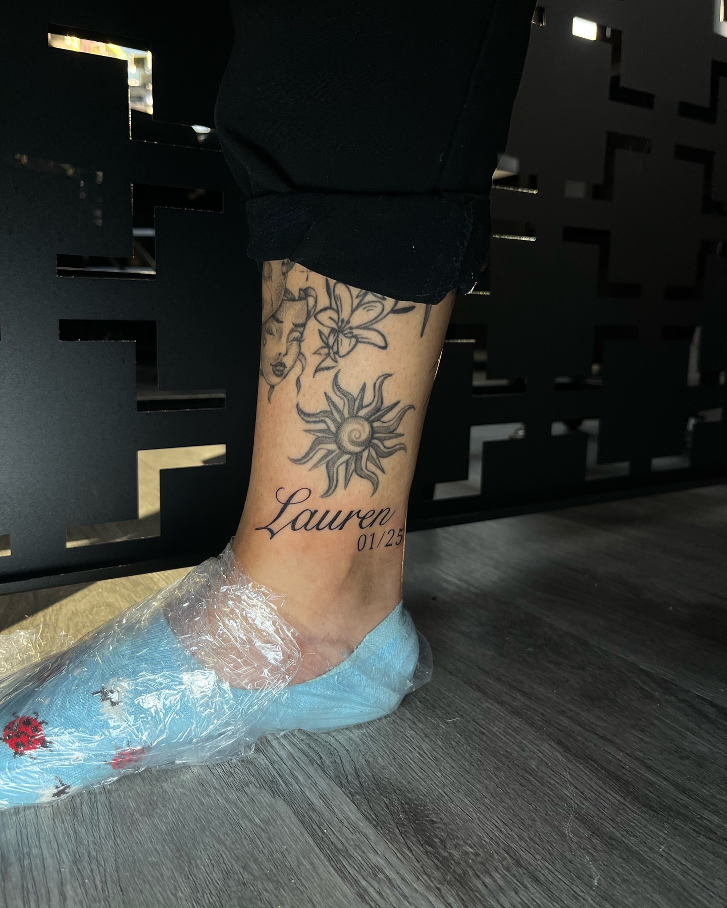 Sun and lily black and grey tattoo on the foot by Connor Arvay