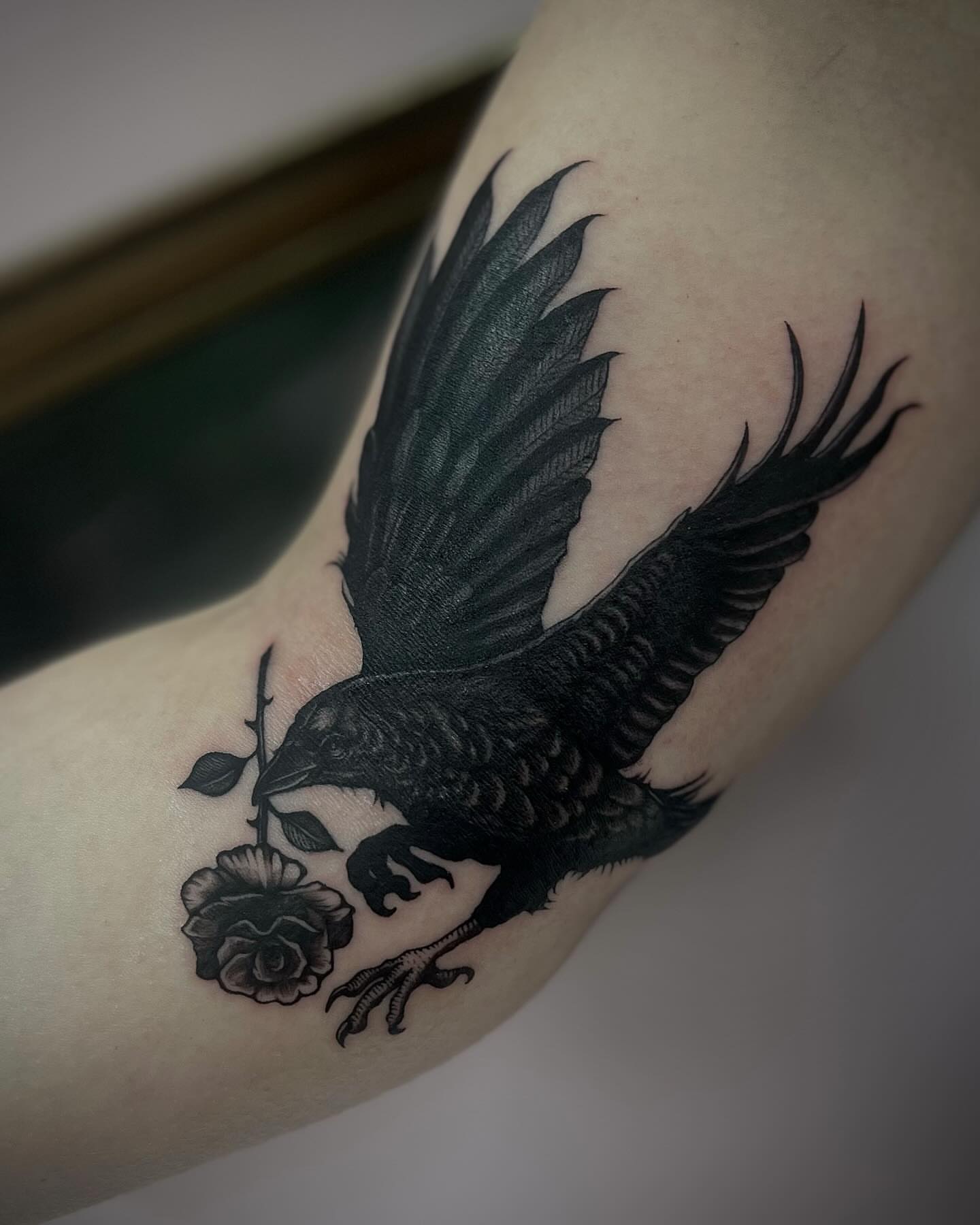 Crow and rose realism tattoo on the forearm by Emily‹𝟹