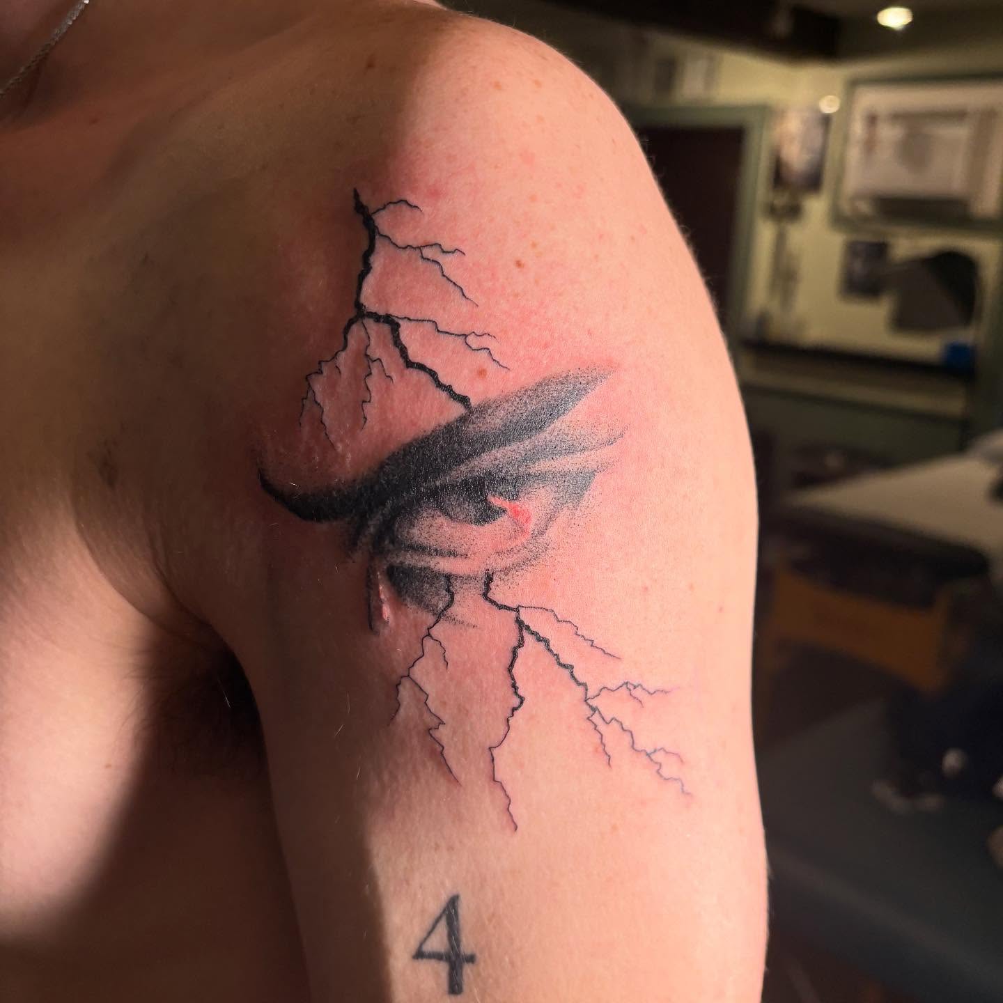 Lightning bolt black and grey tattoo on the shoulder by Nolan Croteau