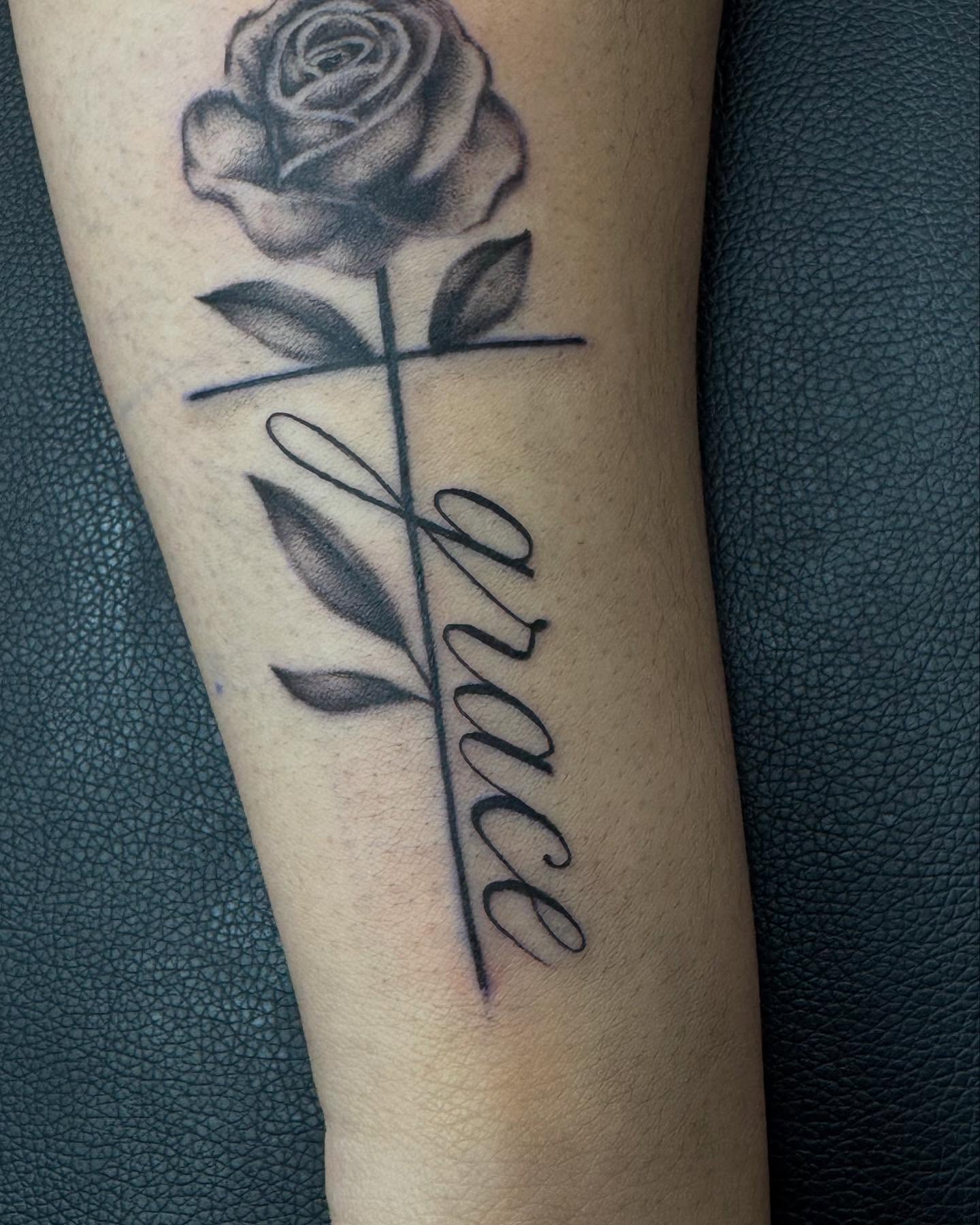 Cross and rose black and grey tattoo on the forearm by Alexa Camacho