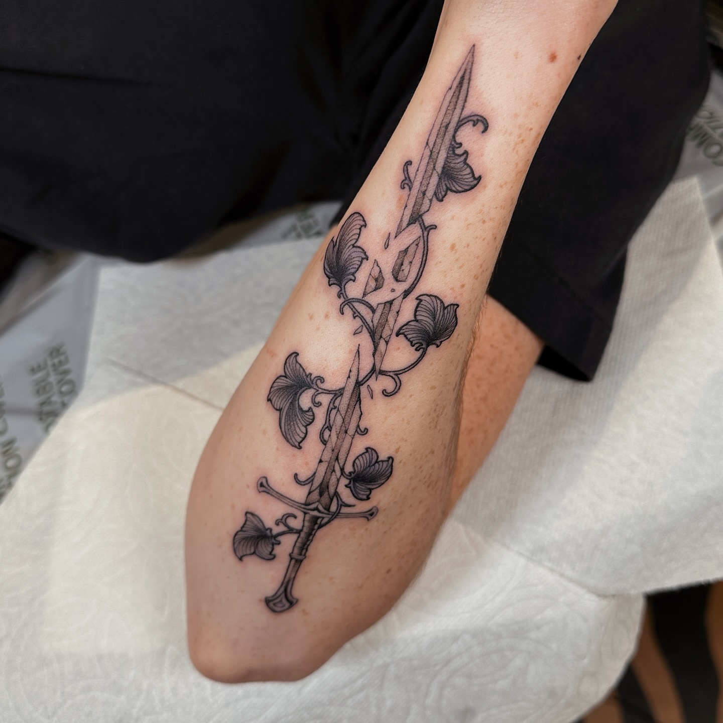 Sword and floral vines black and grey tattoo on the forearm by abigail 🌸