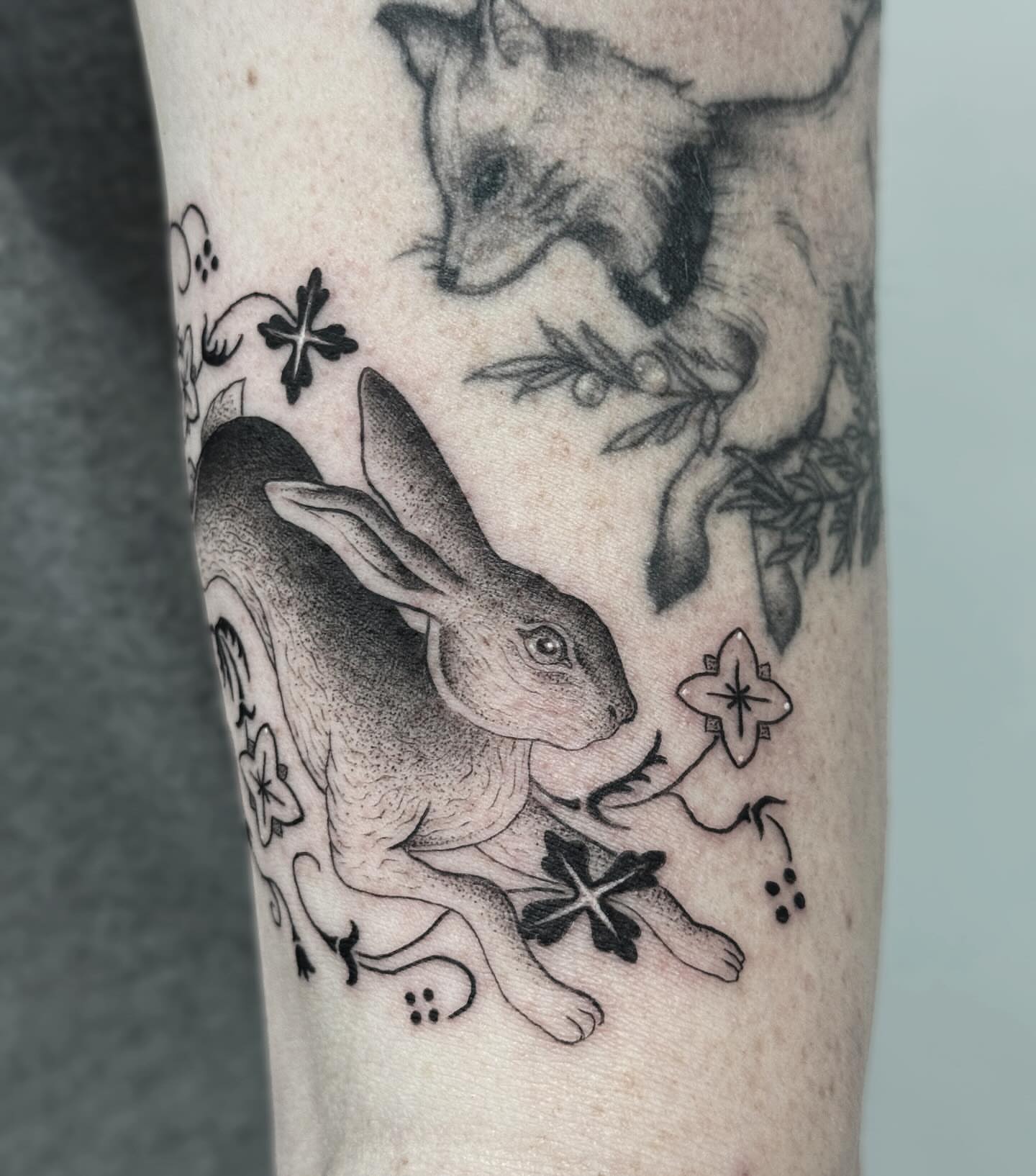 Rabbit and fox dotwork tattoo on the forearm by Writhe Grey