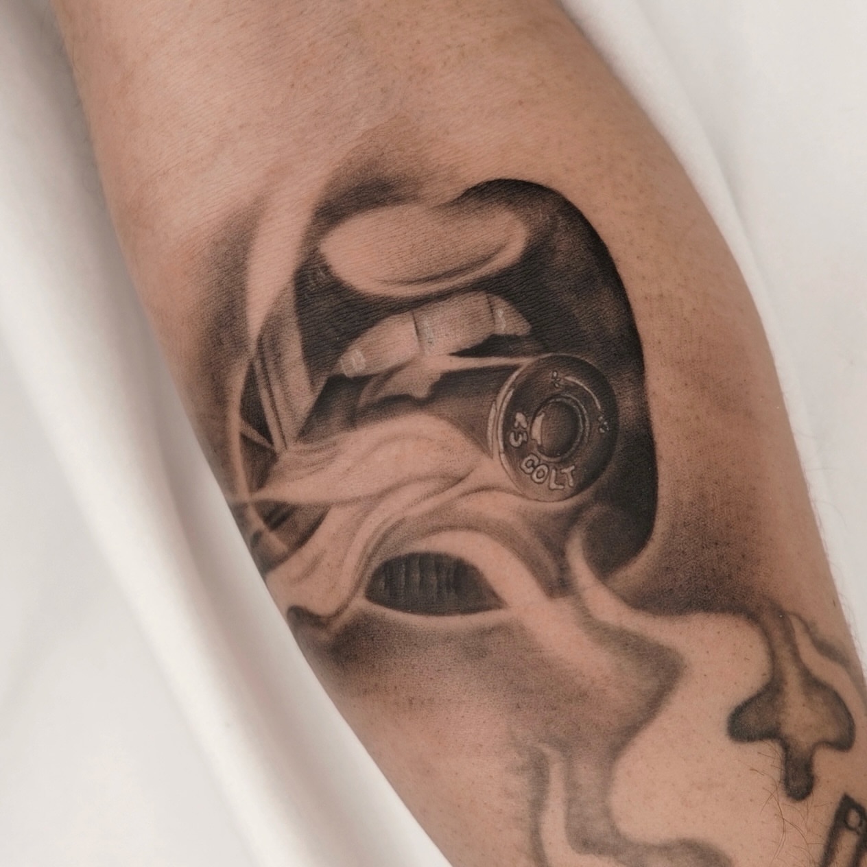 Gun and smoke black and grey tattoo on the forearm by Houston Tattoo Artist