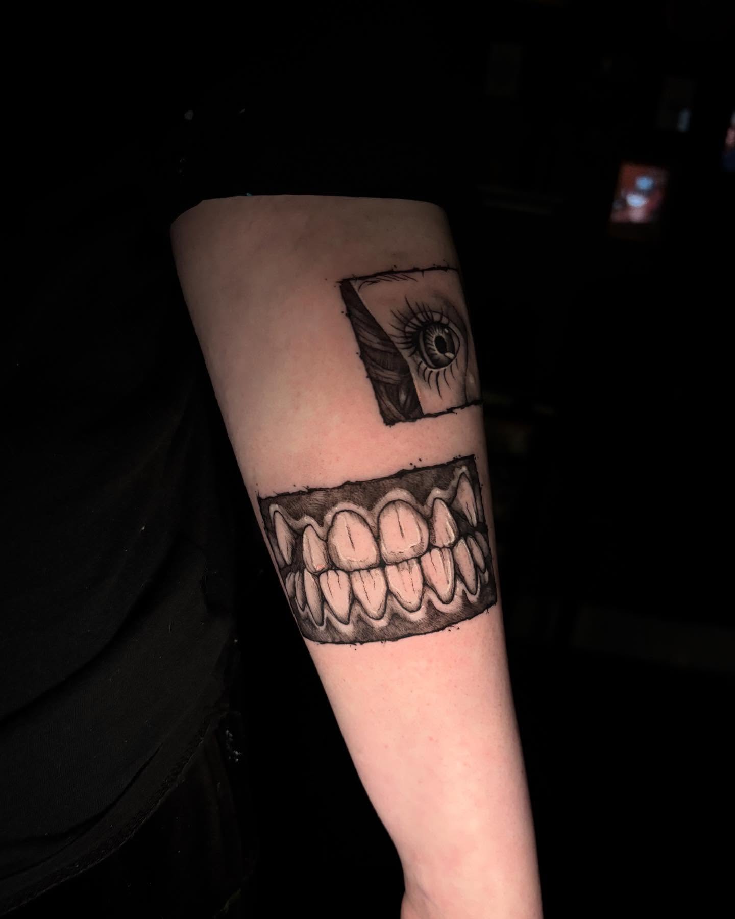 Eye and teeth black and grey tattoo on the forearm by Kayla