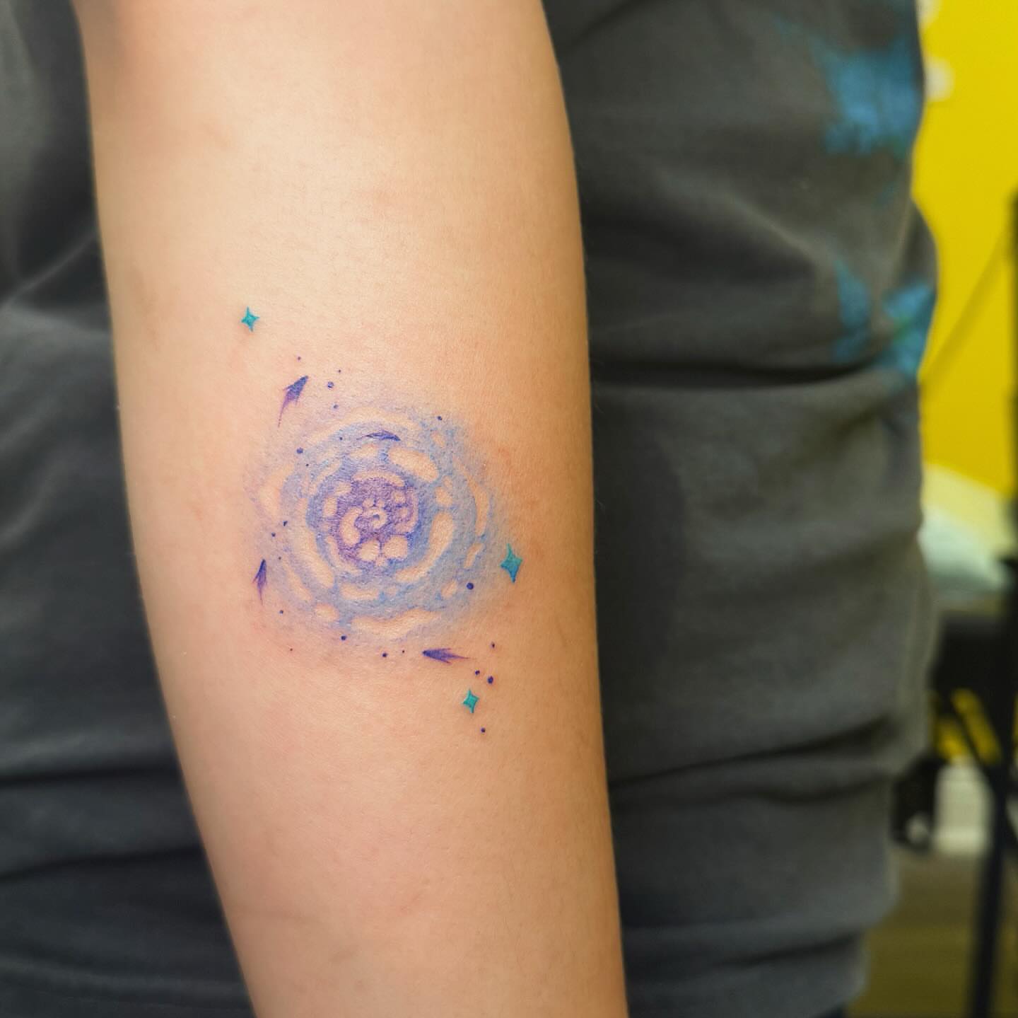 Galaxy watercolor tattoo on the forearm by Echo