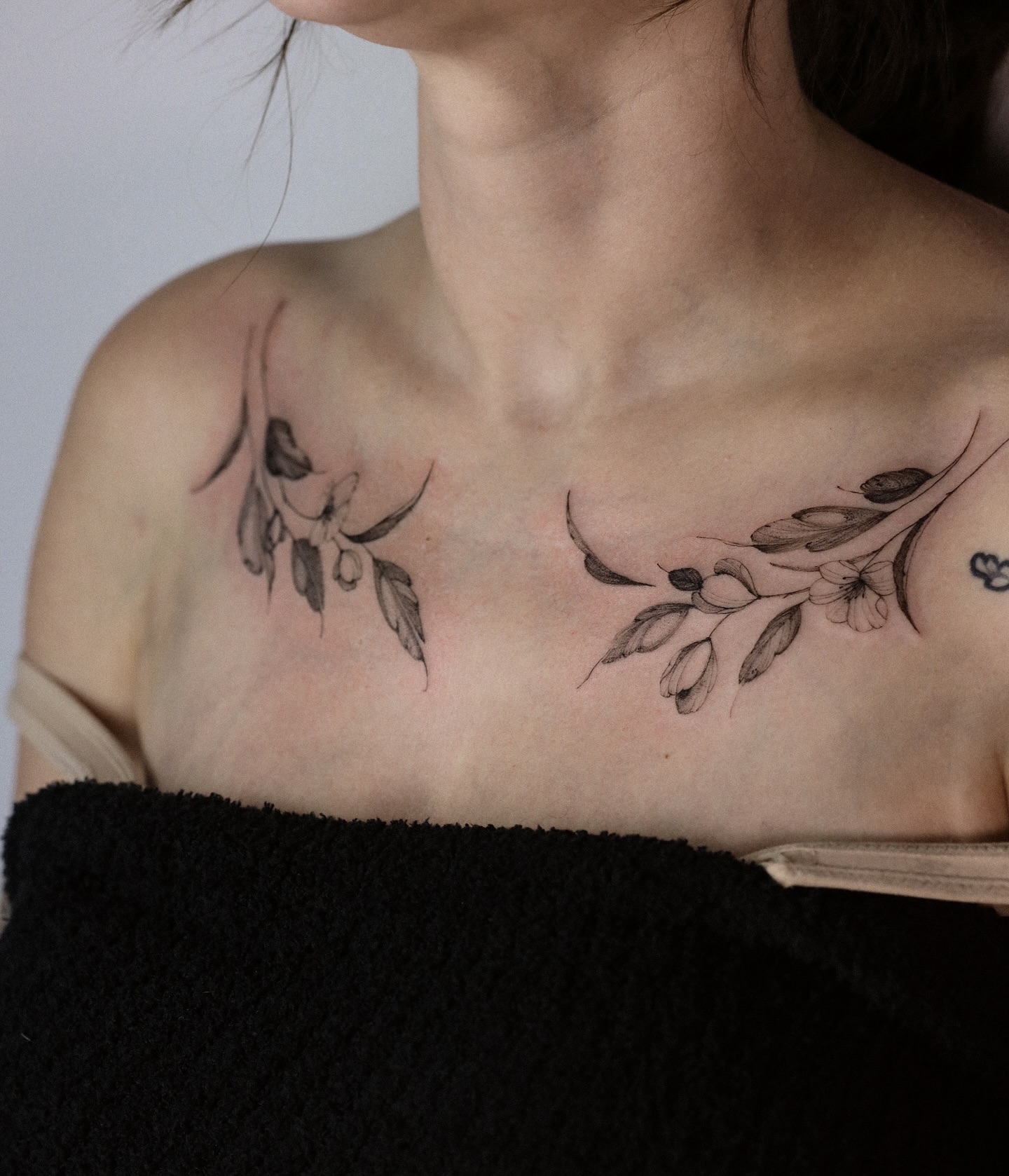 Branch with leaves and flowers black and grey tattoo on the chest by Maria