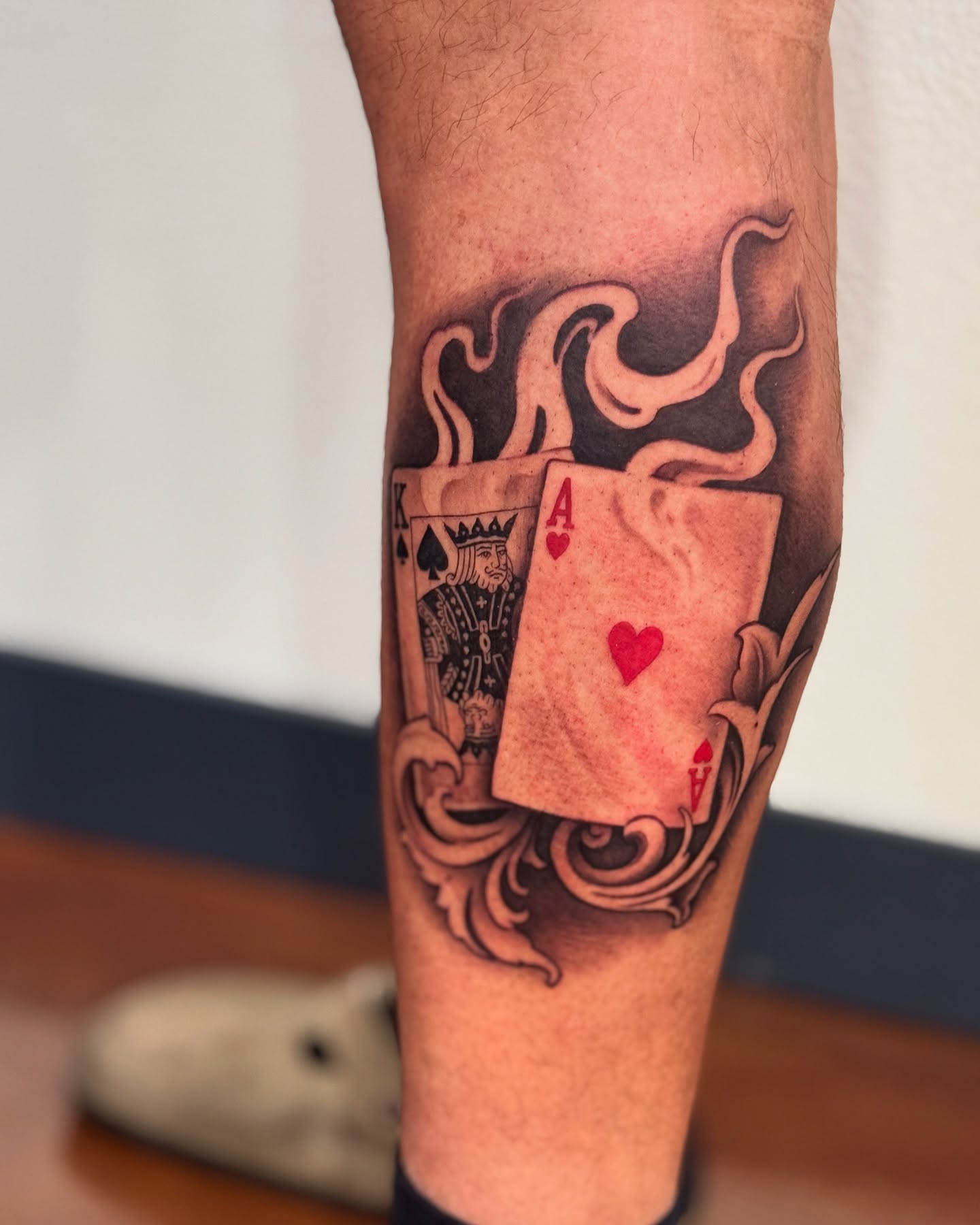 Playing cards black and grey tattoo on the forearm by Julio Ferrer