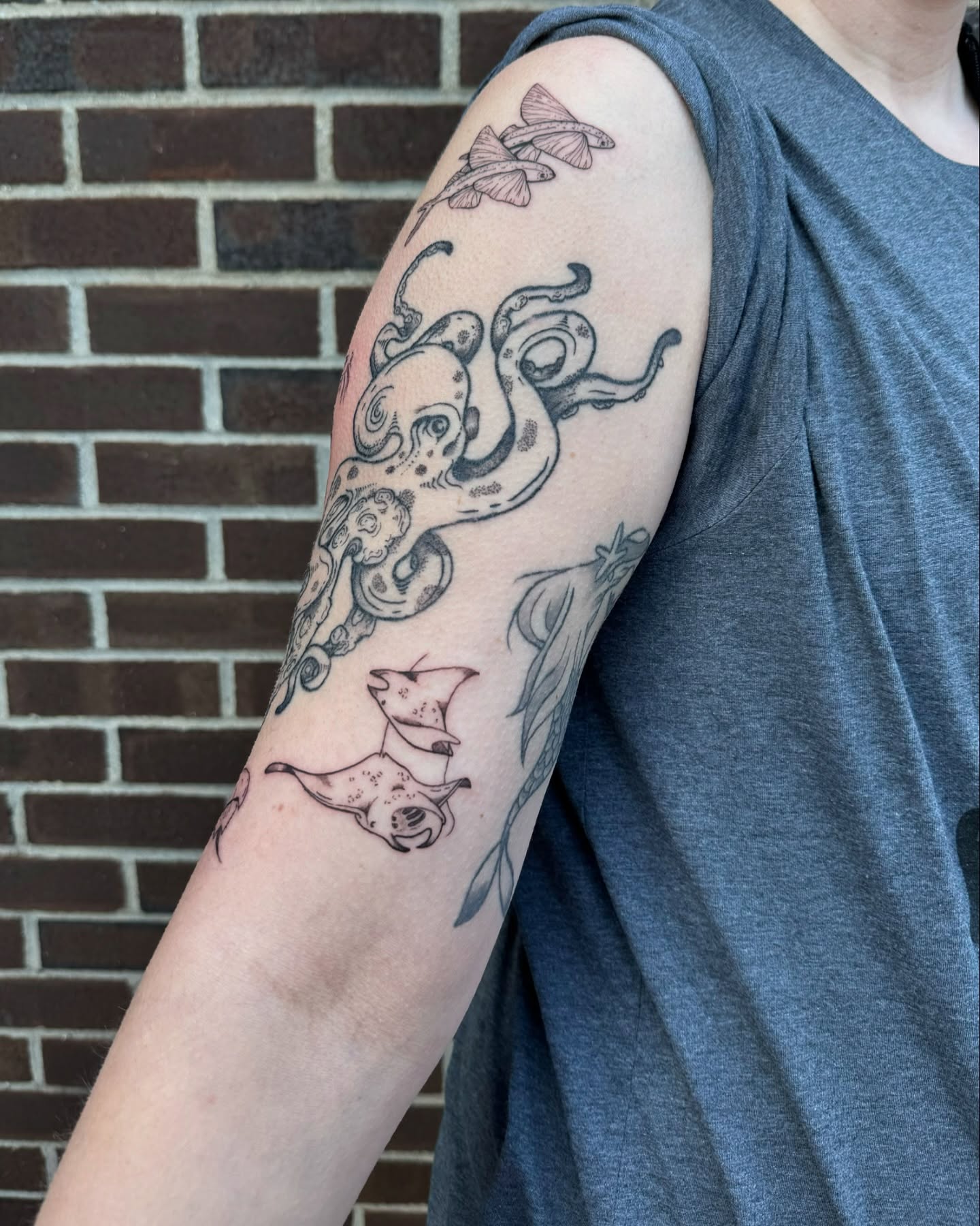 Octopus and stingray black and grey tattoo on the forearm by Milo