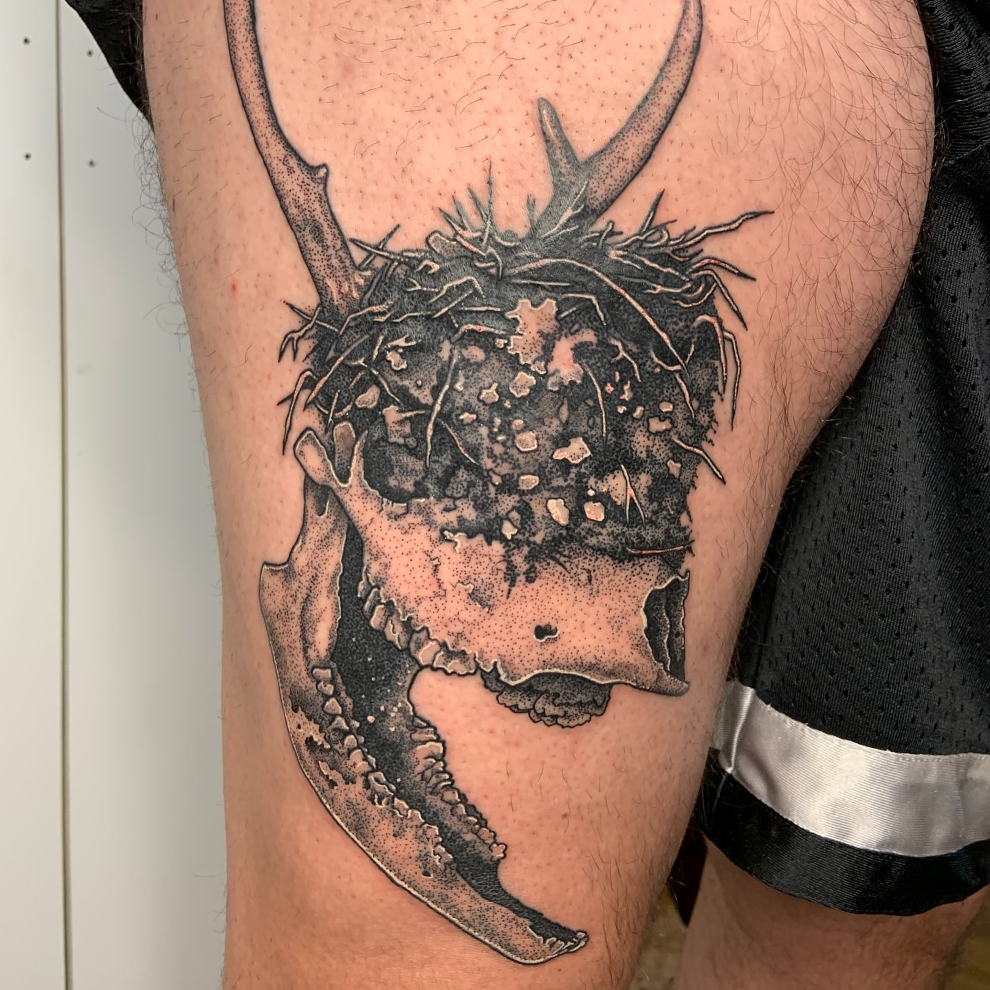Deer skull dotwork tattoo on the thigh by Bombay Pain Co.