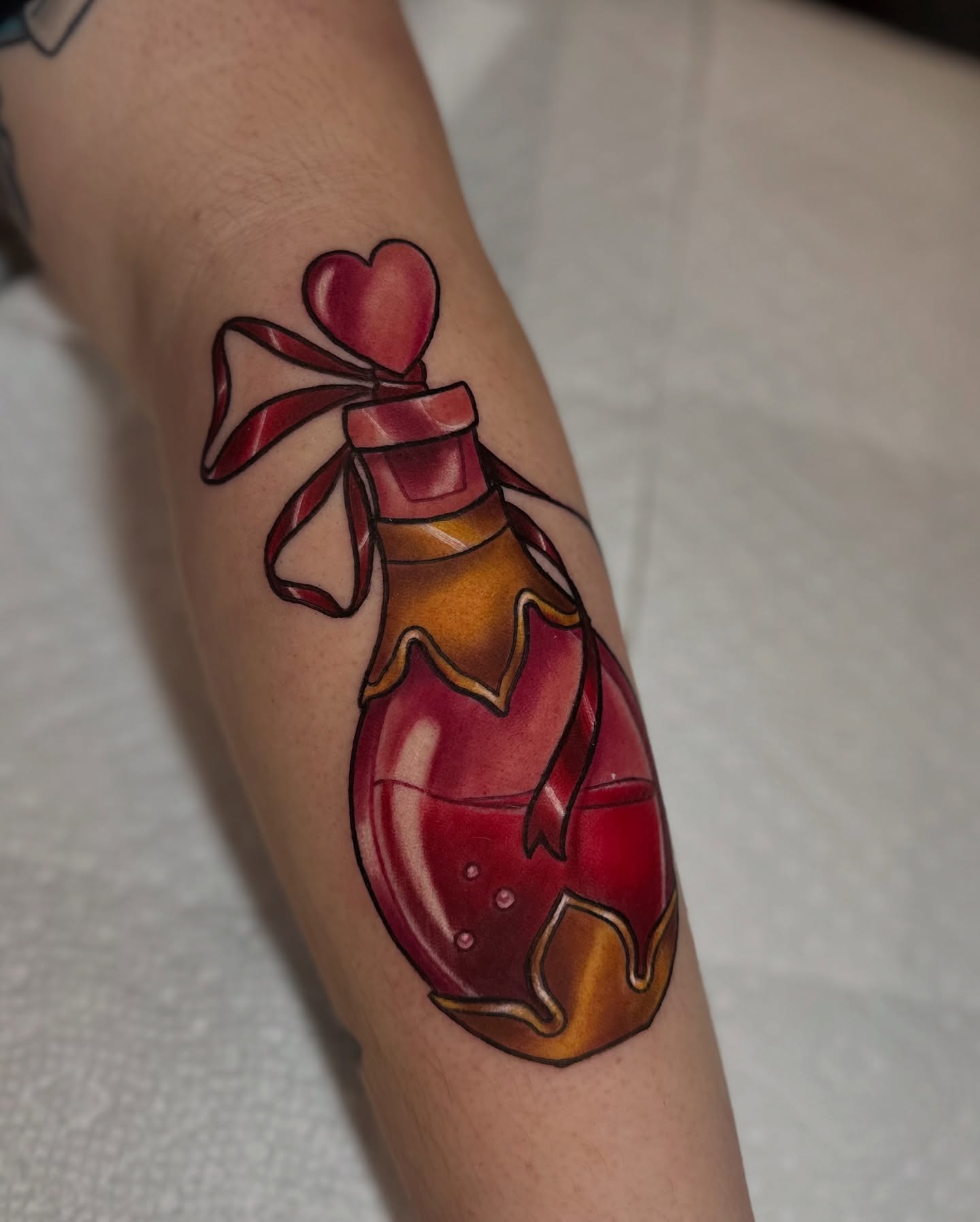 Heart-shaped potion bottle American traditional tattoo on the forearm by ✨Sarah Knapp✨, Eugene, Oregon
