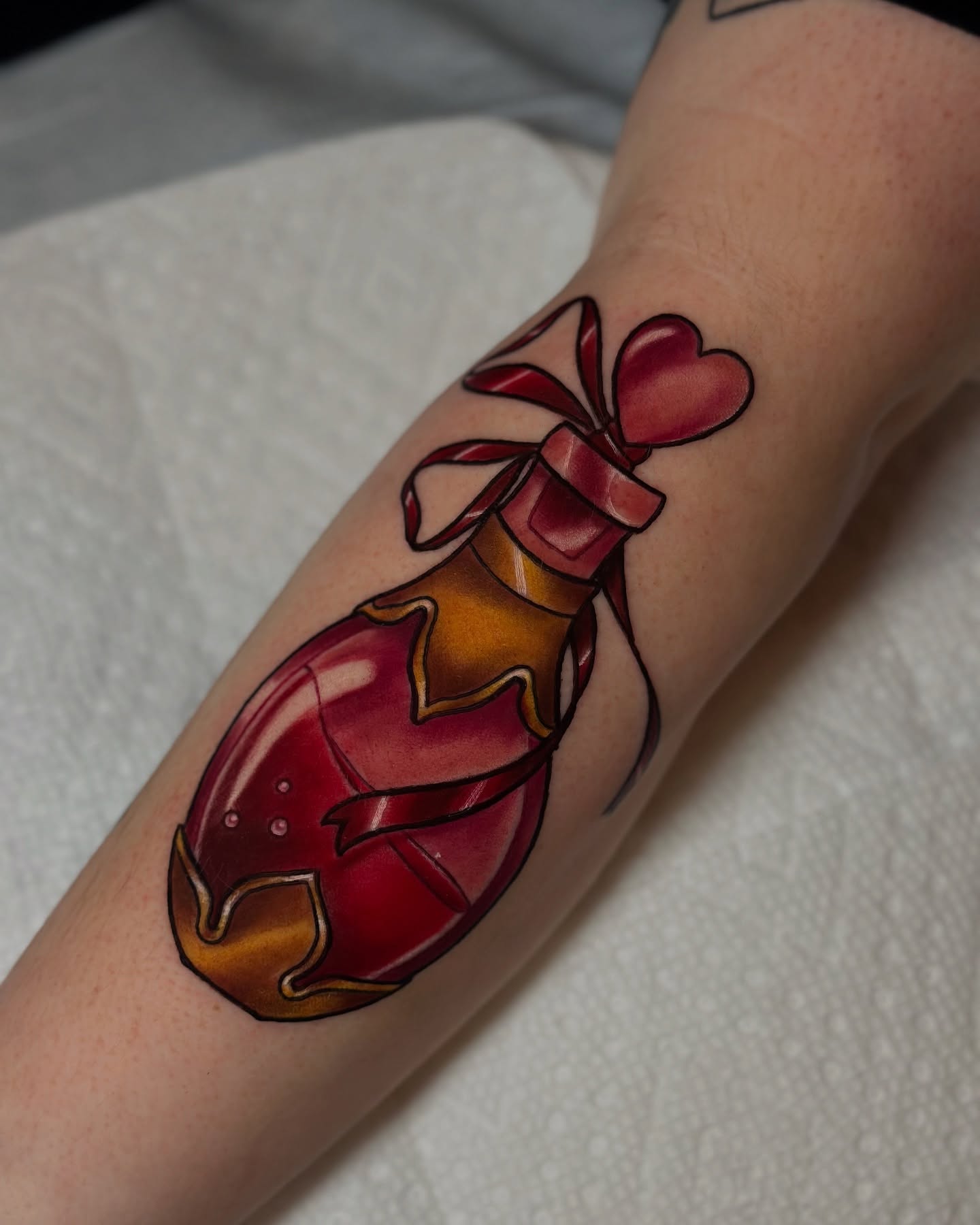 Heart-shaped potion bottle realism tattoo on the forearm by ✨Sarah Knapp✨, Eugene, Oregon