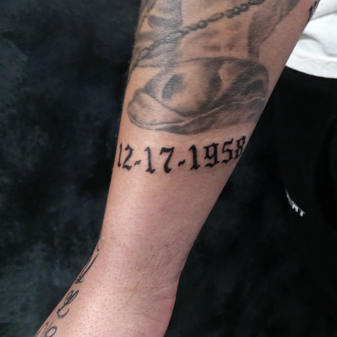 Date black and grey tattoo on the forearm by Cassandra Davis