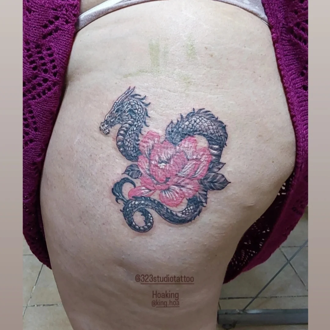 Dragon and flower dotwork tattoo on the thigh by Hoa King