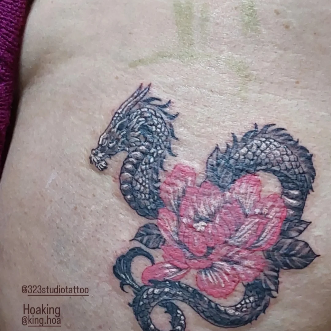Dragon and lotus realism tattoo on the thigh by Hoa King