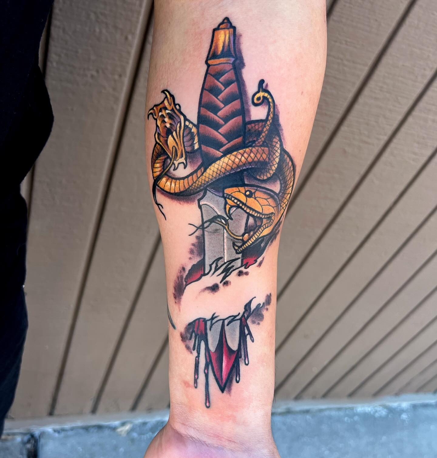 Snake and lighthouse American traditional tattoo on the forearm by Kevin Starai