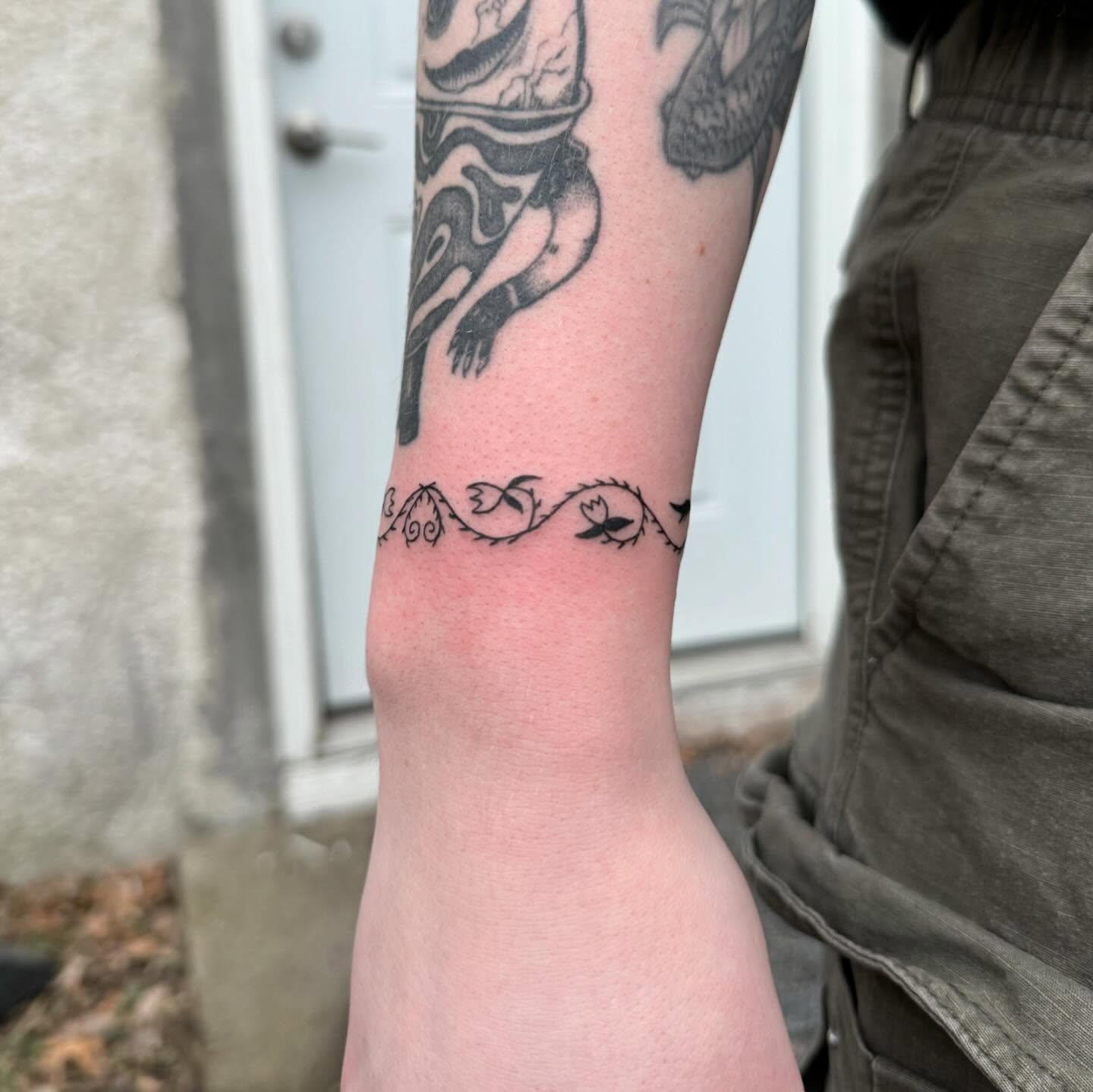 Vine with flowers black and grey tattoo on the forearm by house0fsleep 💤