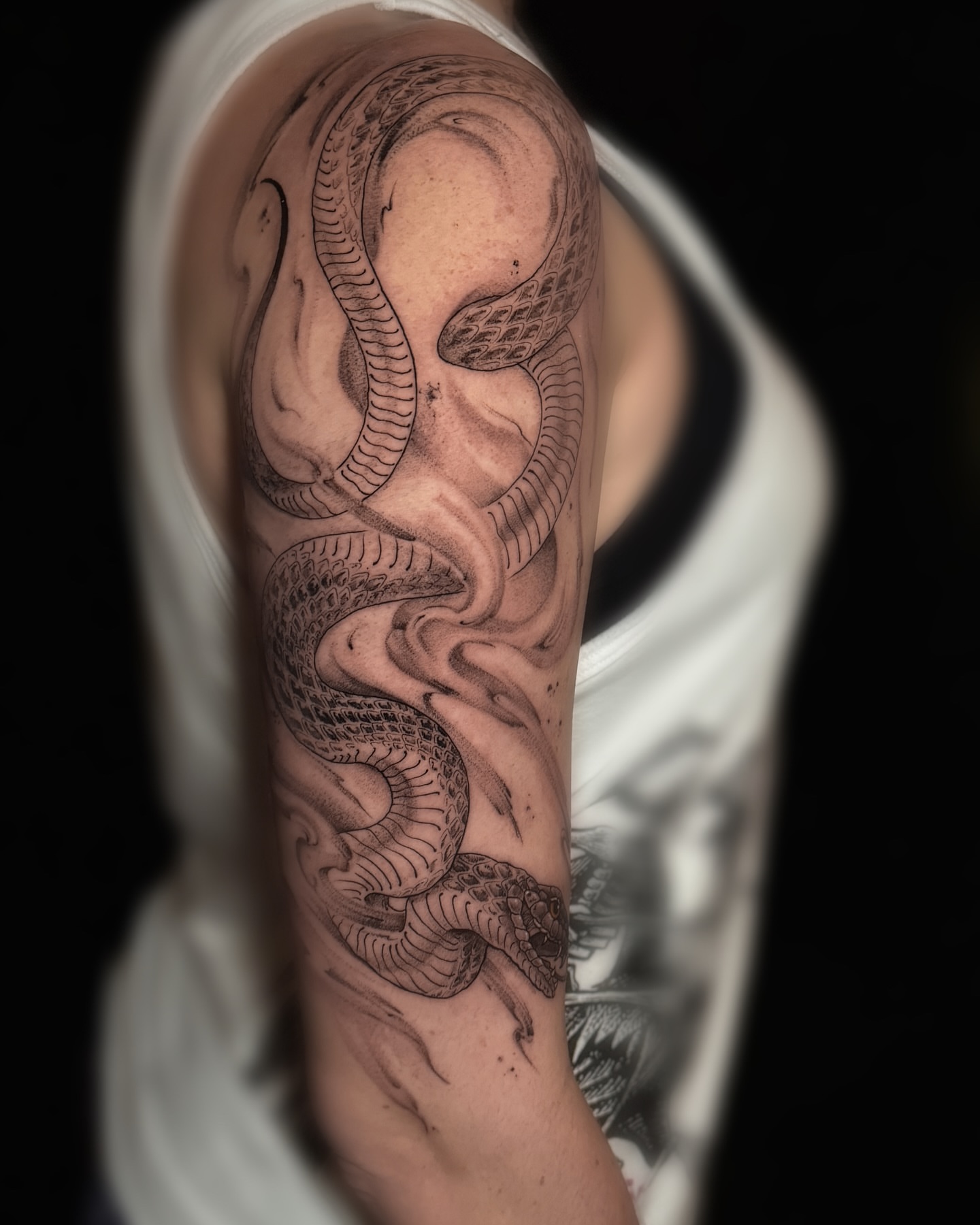 Snake black and grey tattoo on the upper arm by Ksu Storm, San Francisco, California