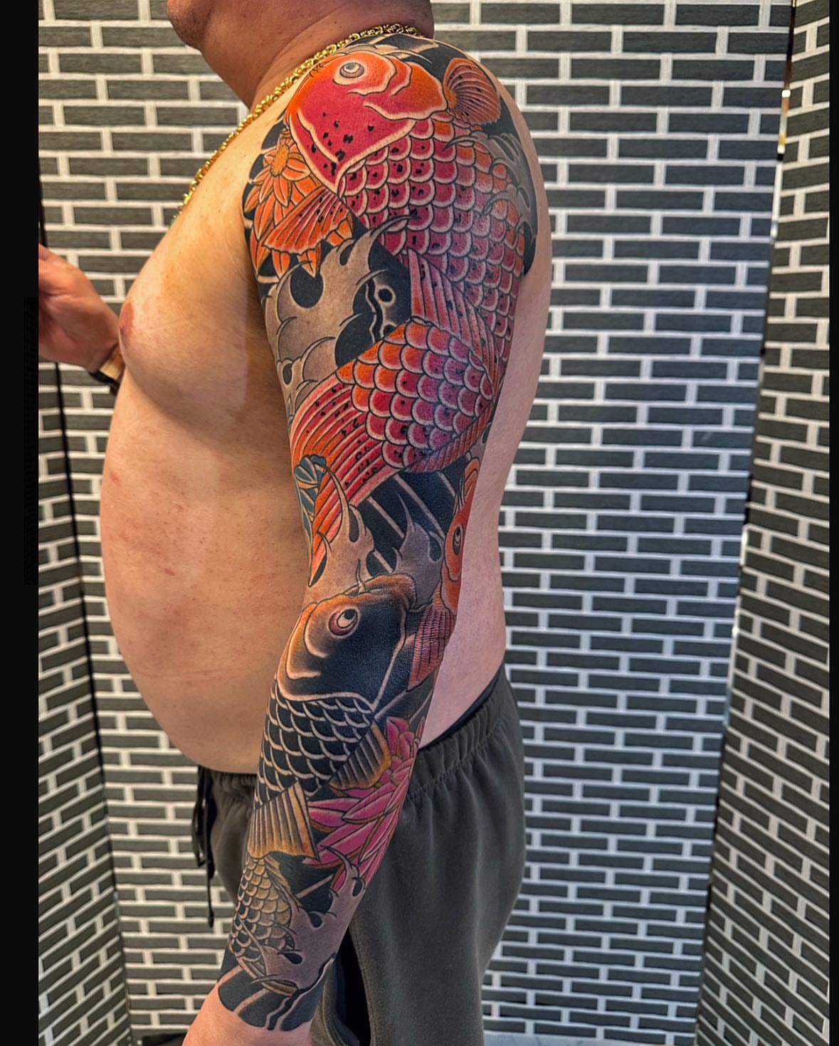 Koi fish japanese irezumi tattoo on the upper arm by Xiaojun Yin, Vancouver, British Columbia