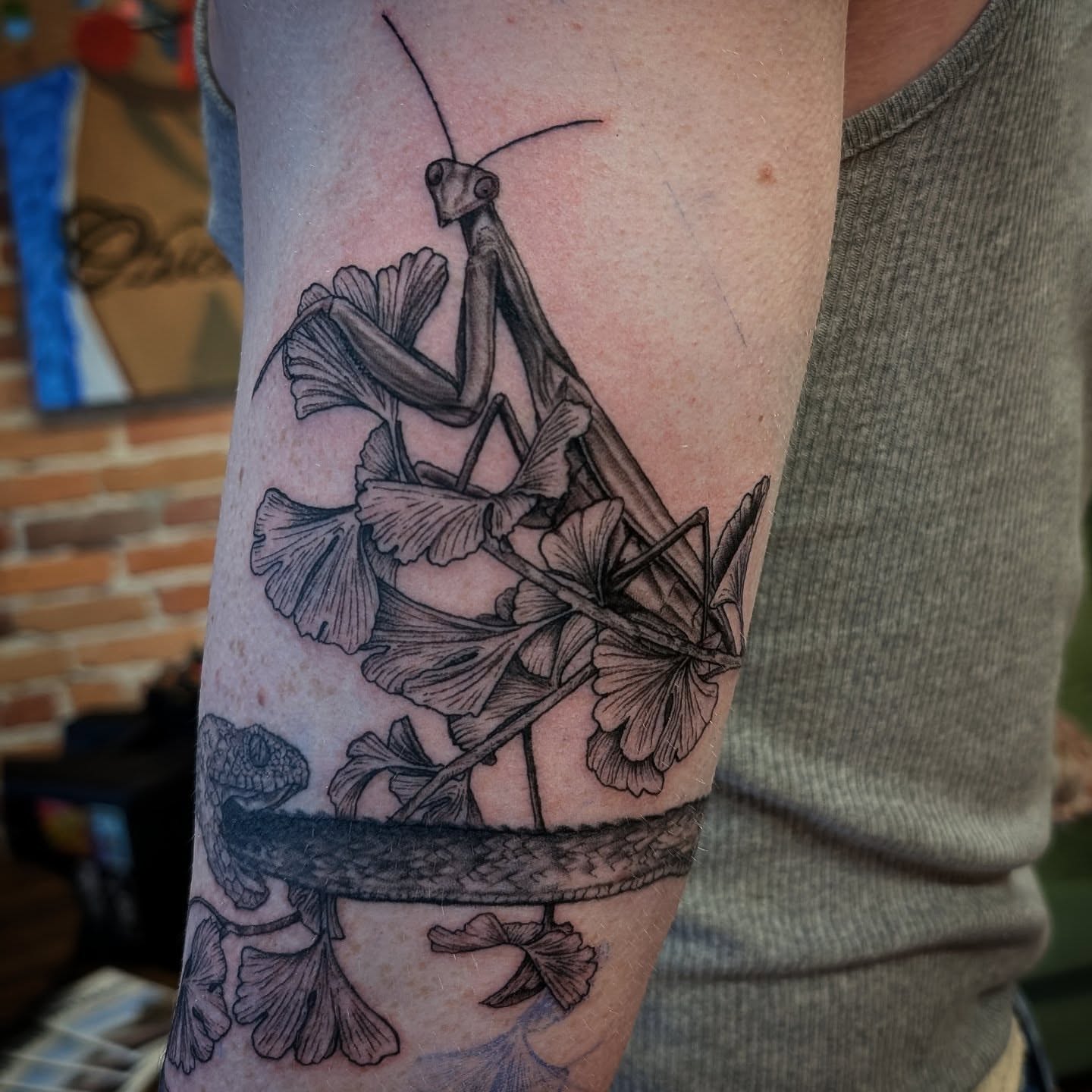 Praying mantis and ginkgo leaves realism tattoo on the forearm by Krista Mc