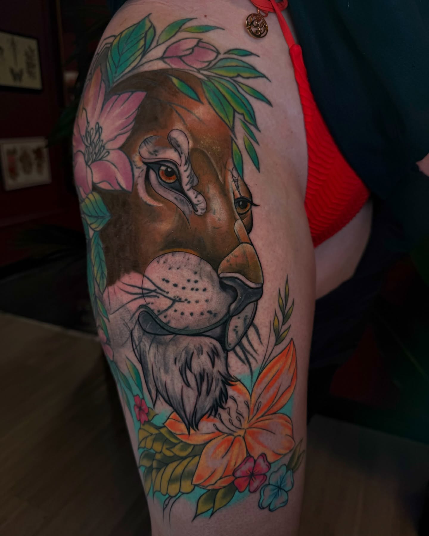Lion with flowers realism tattoo on the thigh by Gabby Finearts
