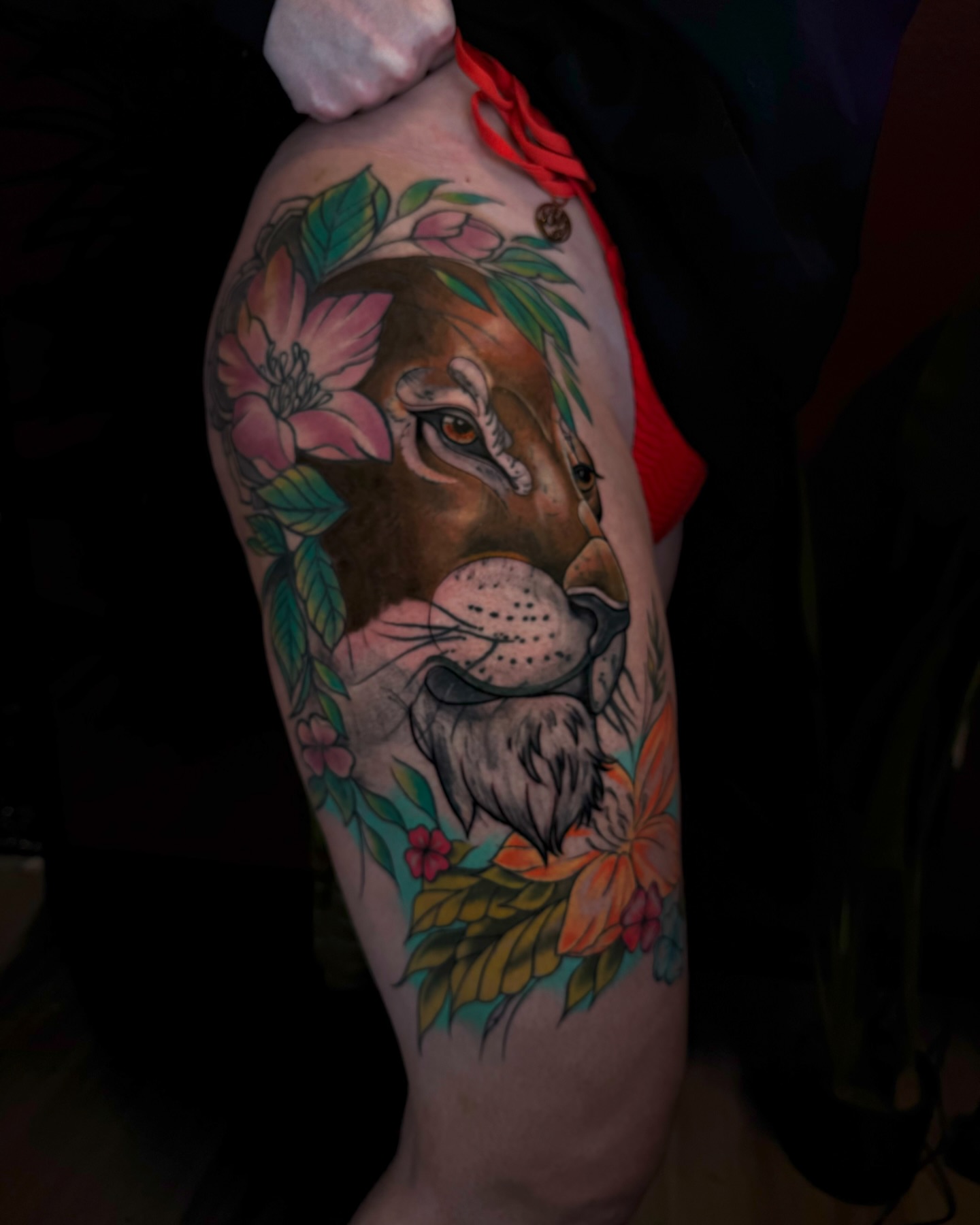 Lion with floral wreath realism tattoo on the thigh by Gabby Finearts